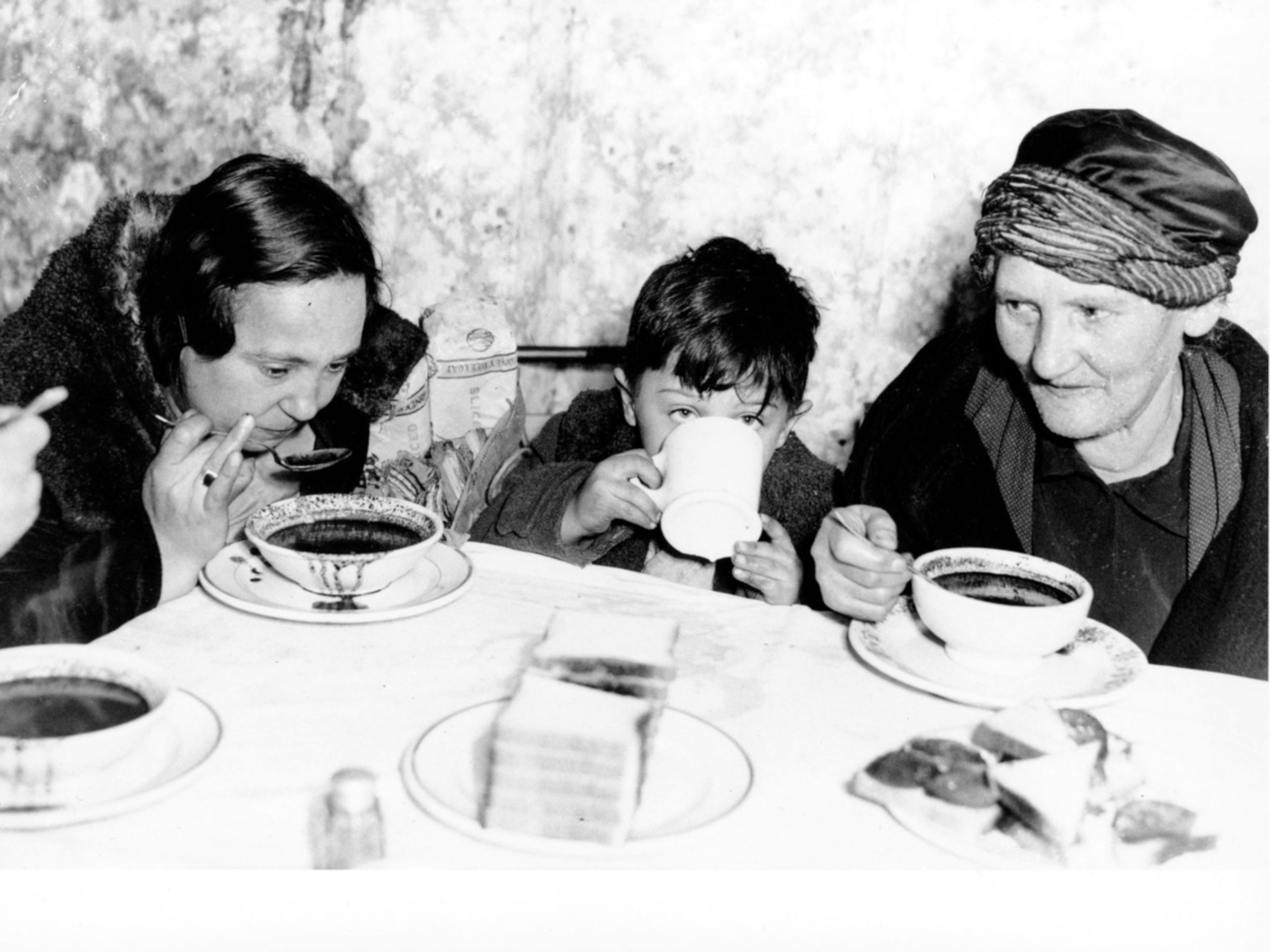 Dos mujeres y un niño desayunan en un comedor de beneficencia tras la Crisis del 29