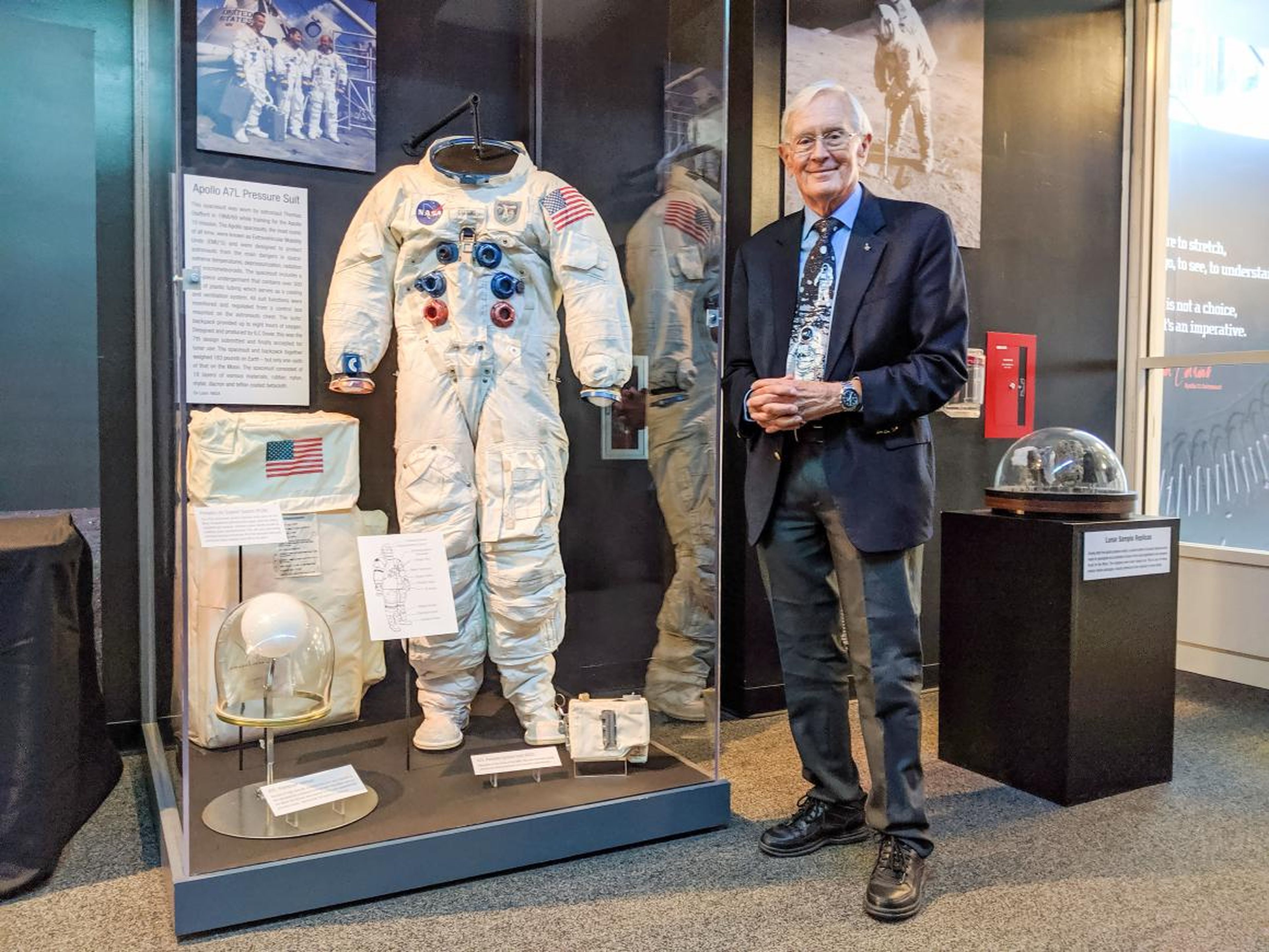 Duke, quien caminó por la luna en la misión del Apolo 16, posa junto al traje espacial en el Museo de los Orígenes de la Aviación de Nueva York.