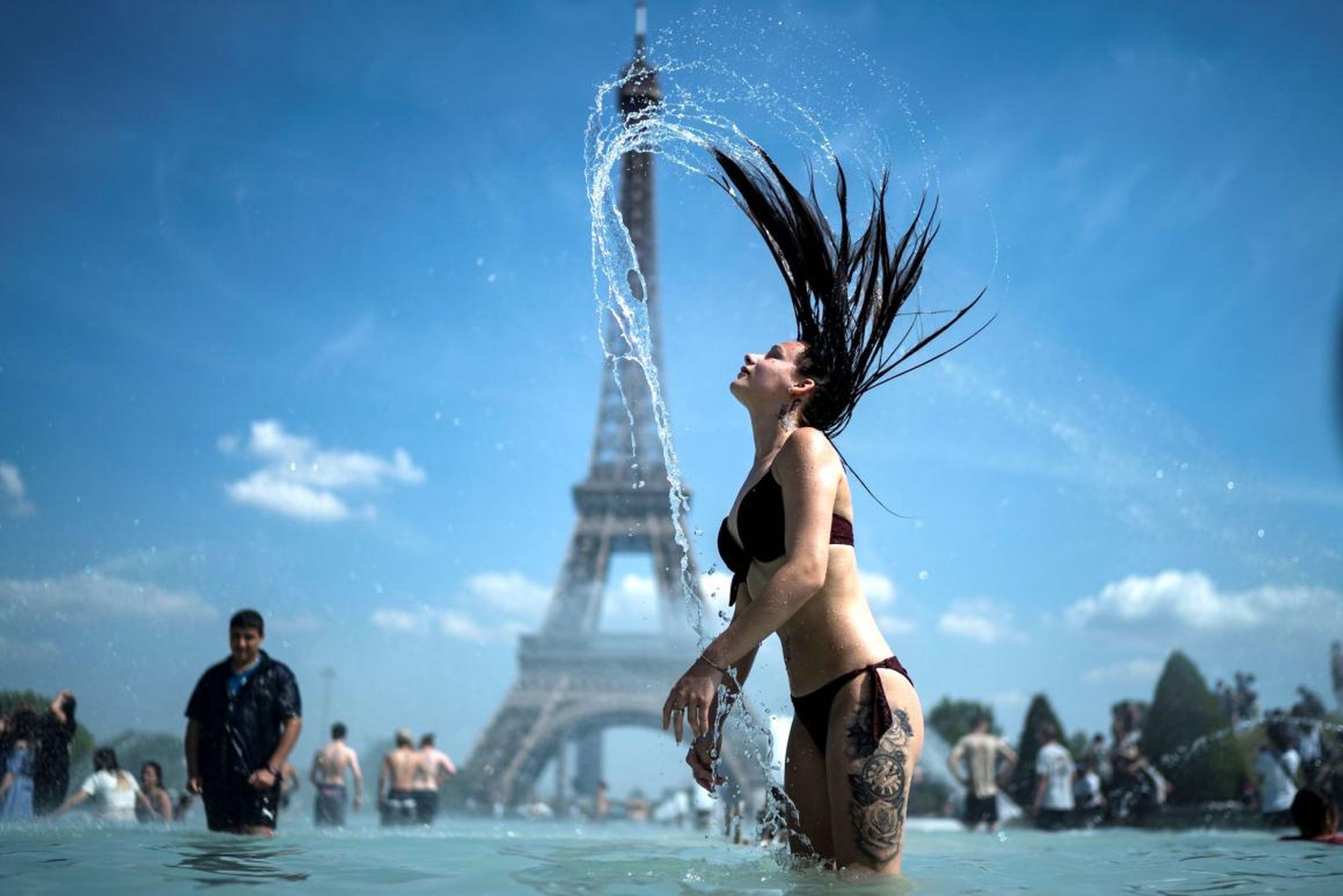 A woman in the fountain of the Trocadero esplanade in Paris.