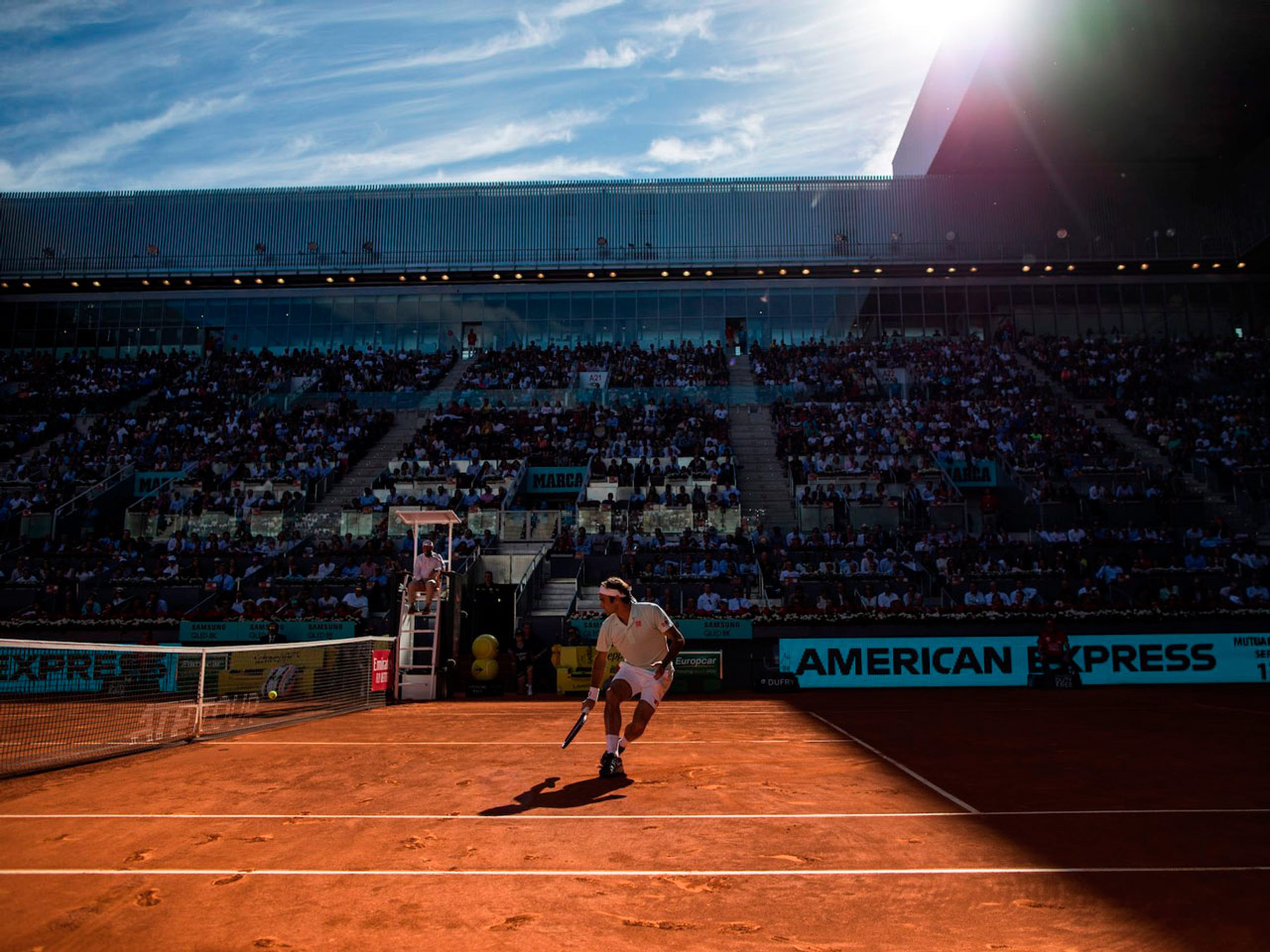 Federer corre hacia la red bajo el cielo de Madrid
