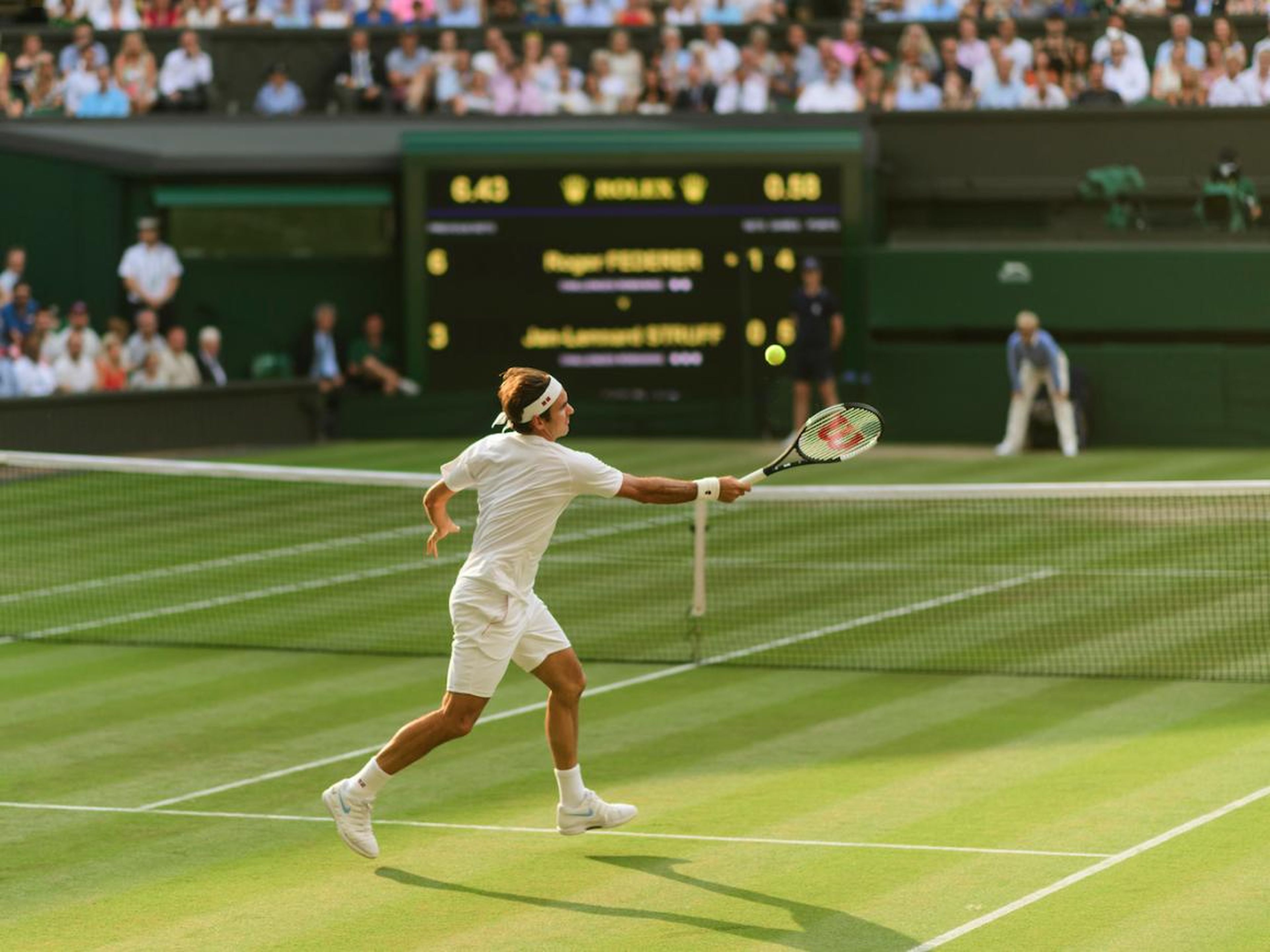Federer hits a return at Wimbledon 2018.