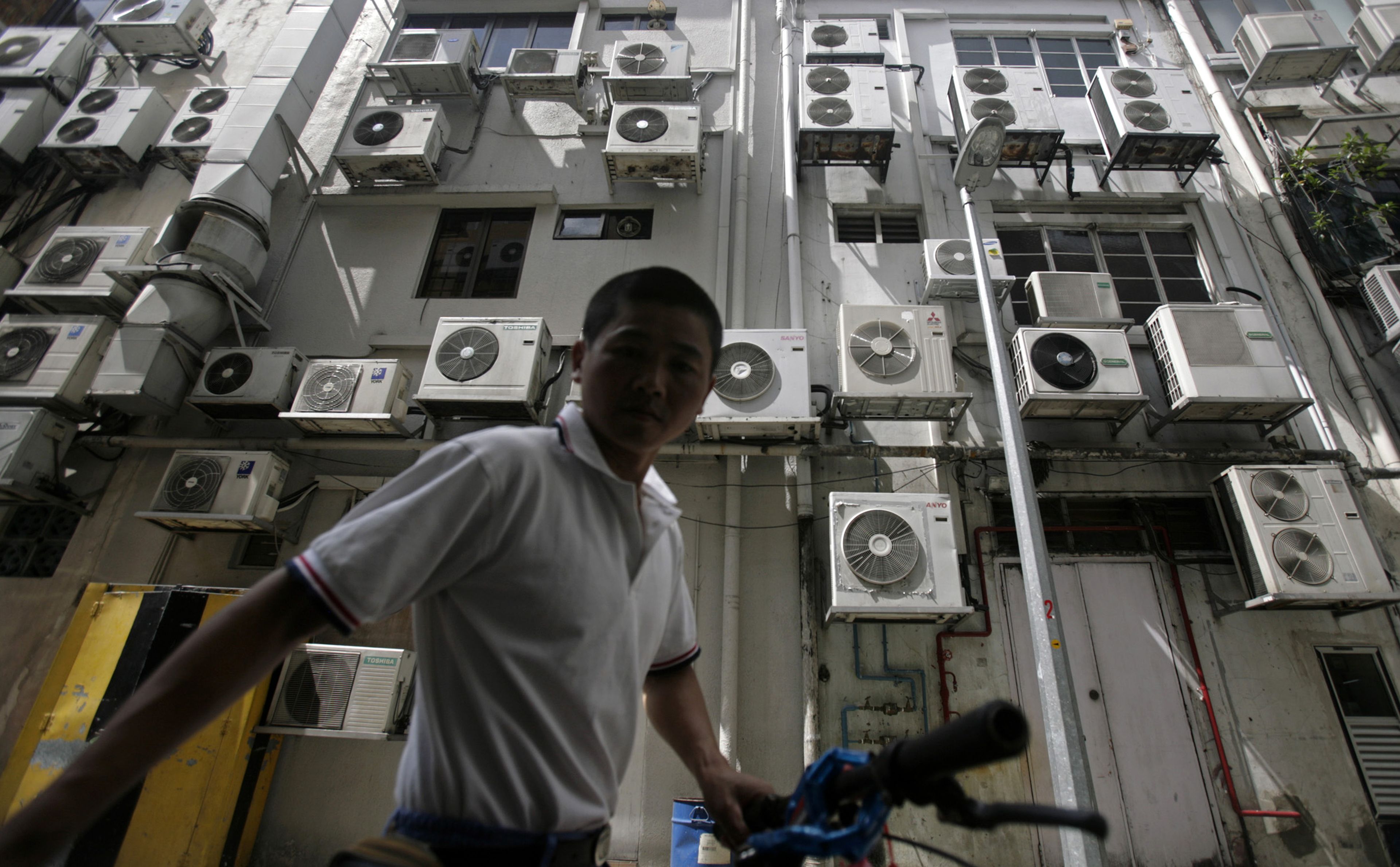 Hombre frente a un edificio repleto de aire acondicionado en Singapore.