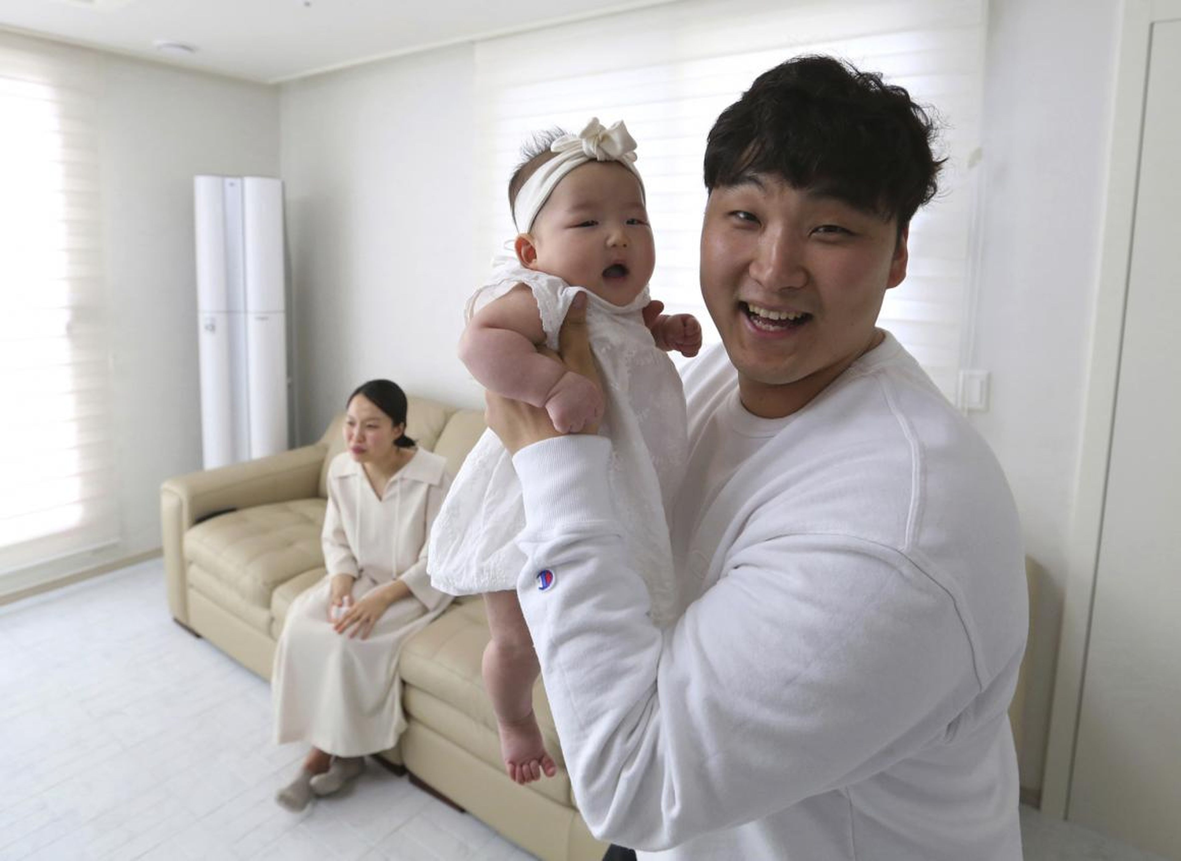 Lee Dong-kil sostiene a su hija, que nació el 31 de diciembre y cumplió dos años al día siguiente bajo el sistema de edad de Corea del Sur.