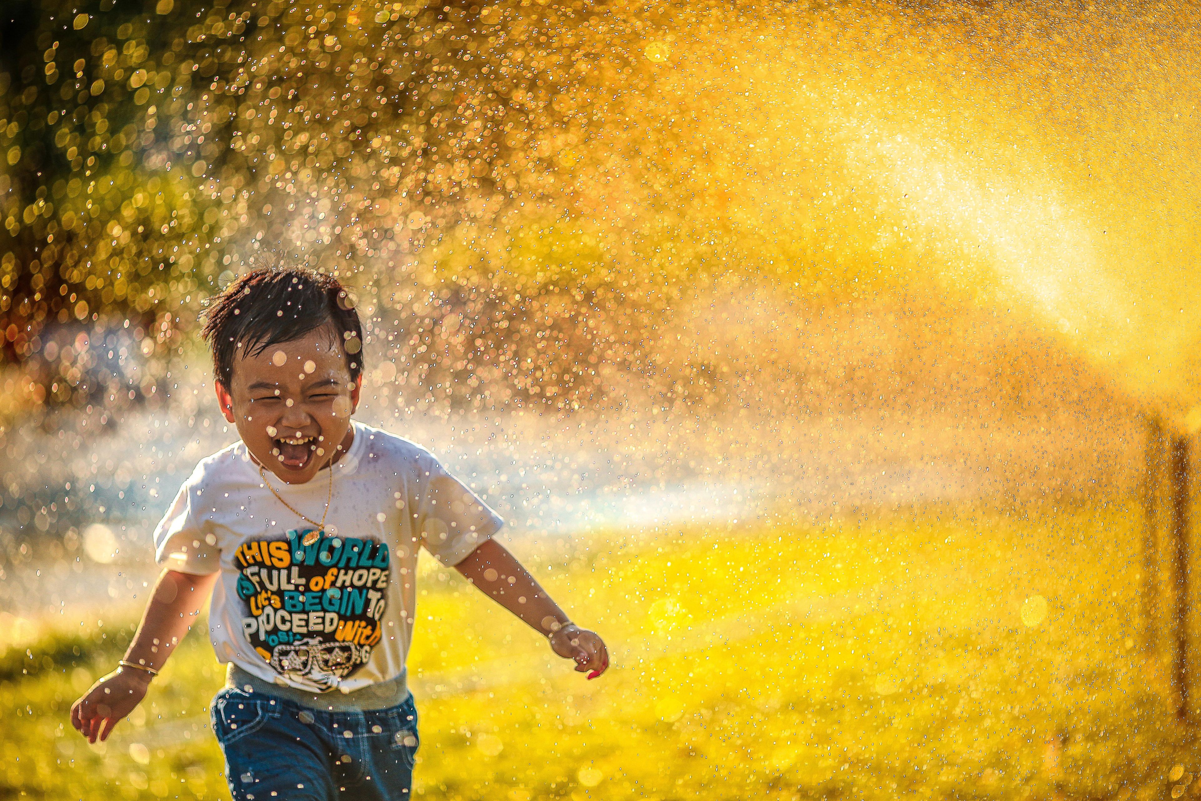 Un niño pequeño jugando con un aspersor de agua