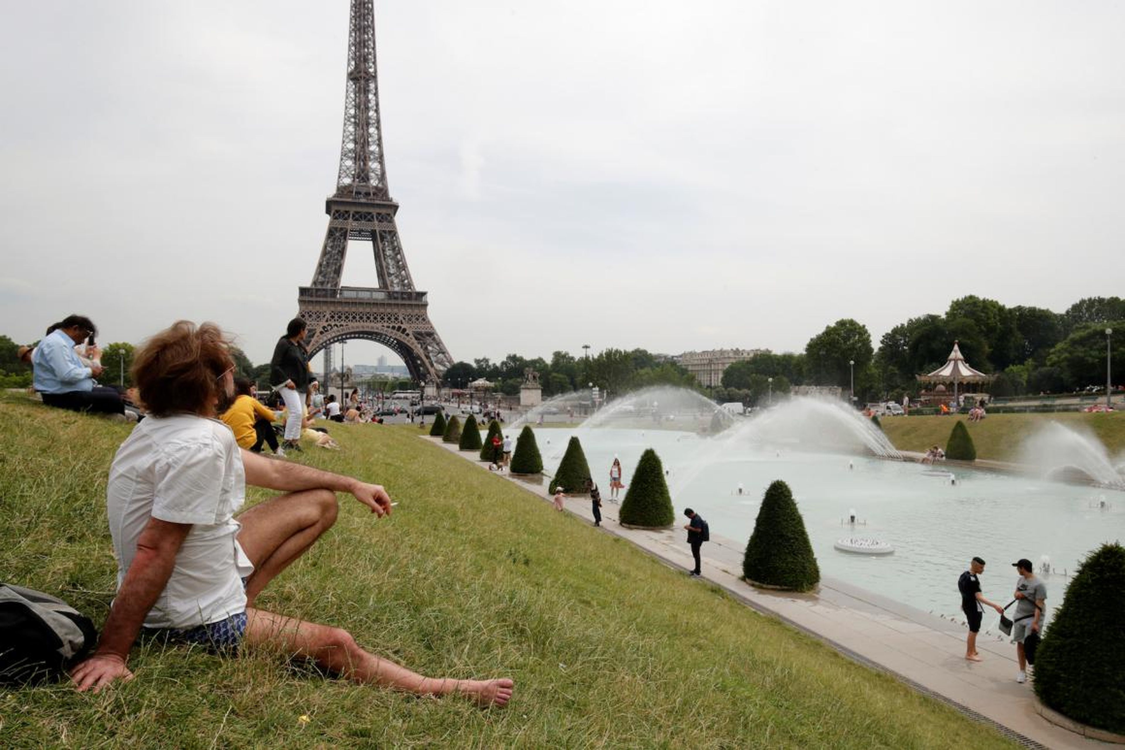 People sunbathe near the Trocadero fountains and the Eiffel tower in Paris as a heatwave is expected in much of the country on Monday.