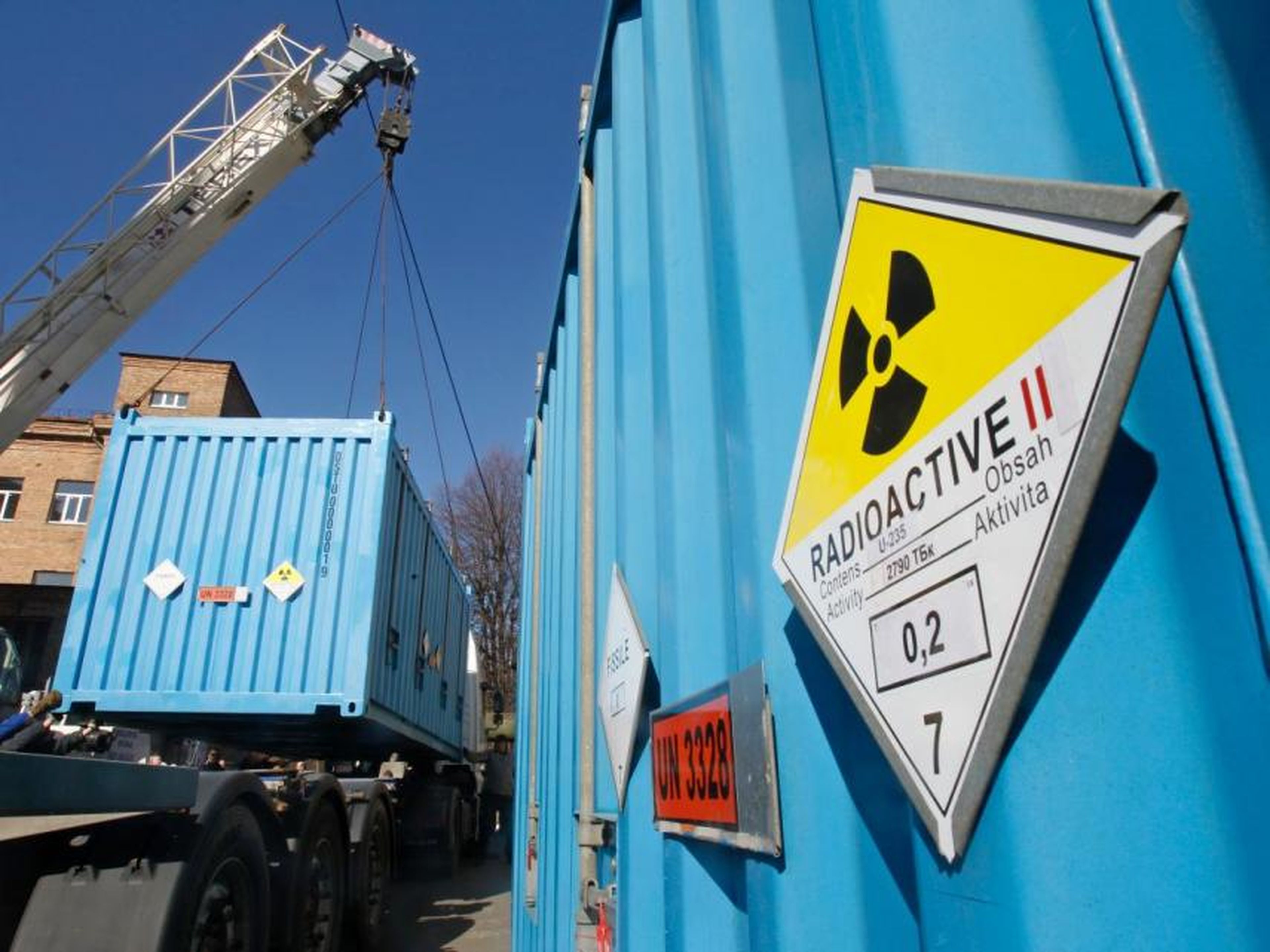 Trabajadores colocan un contenedor con uranio altamente enriquecido en un camión en una instalación de investigación nuclear en Kiev el 24 de marzo de 2012.