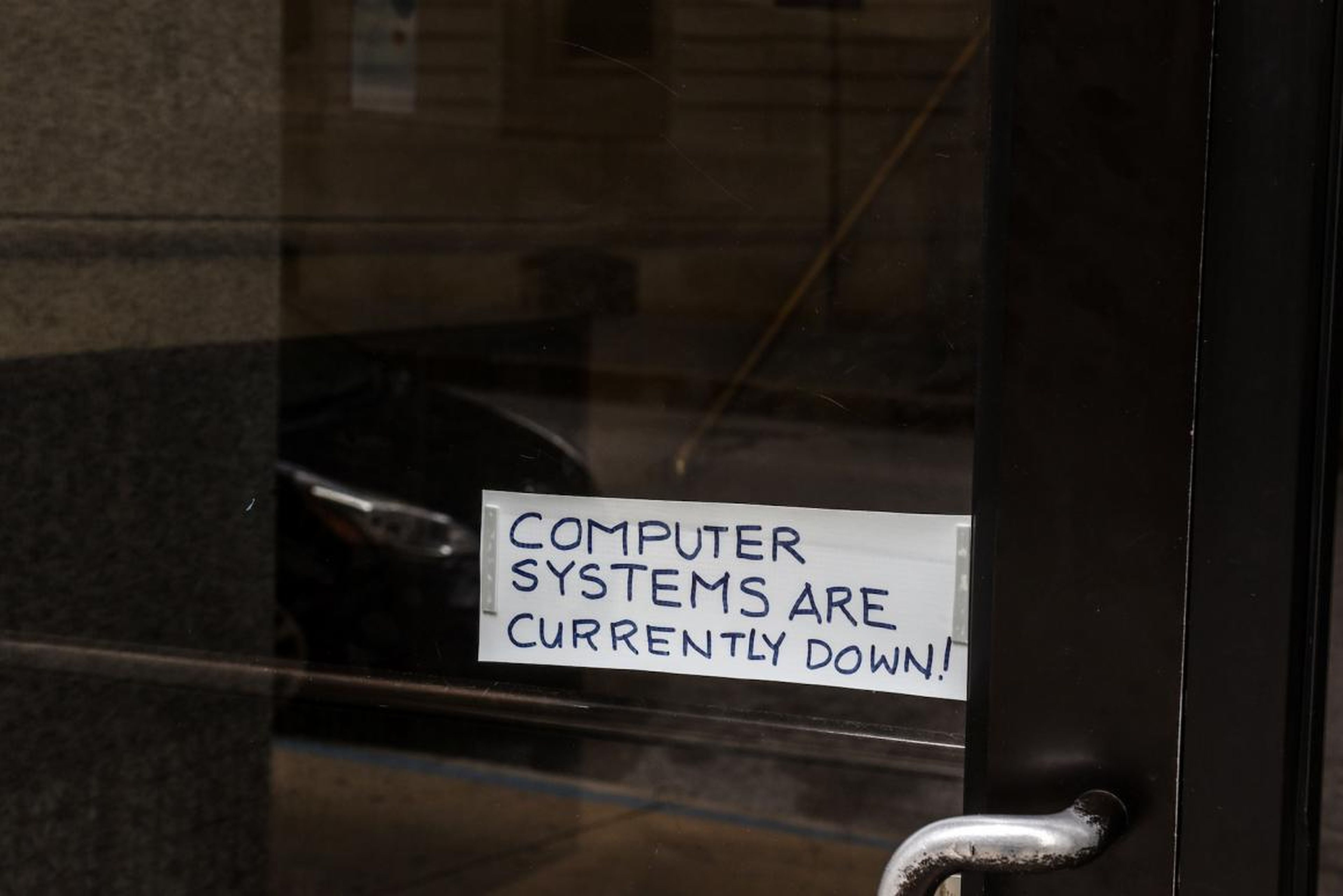 A sign referring to the hacked computer system of Baltimore taped to a door near Baltimore City Hall in May.