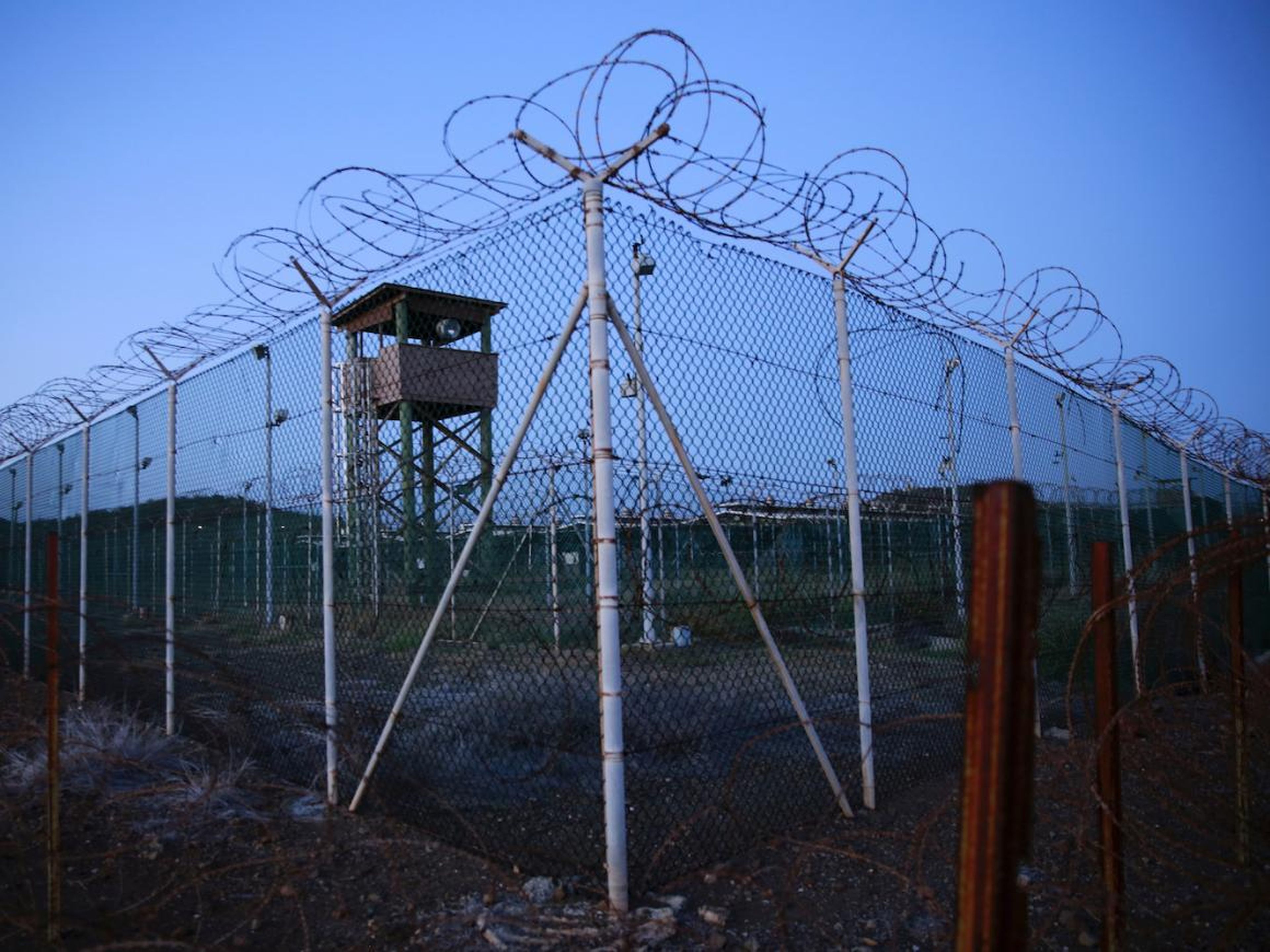La valla metálica y el alambre de púas rodean una torre de guardia abandonada dentro del campo Delta de la prisión de Guantánamo.