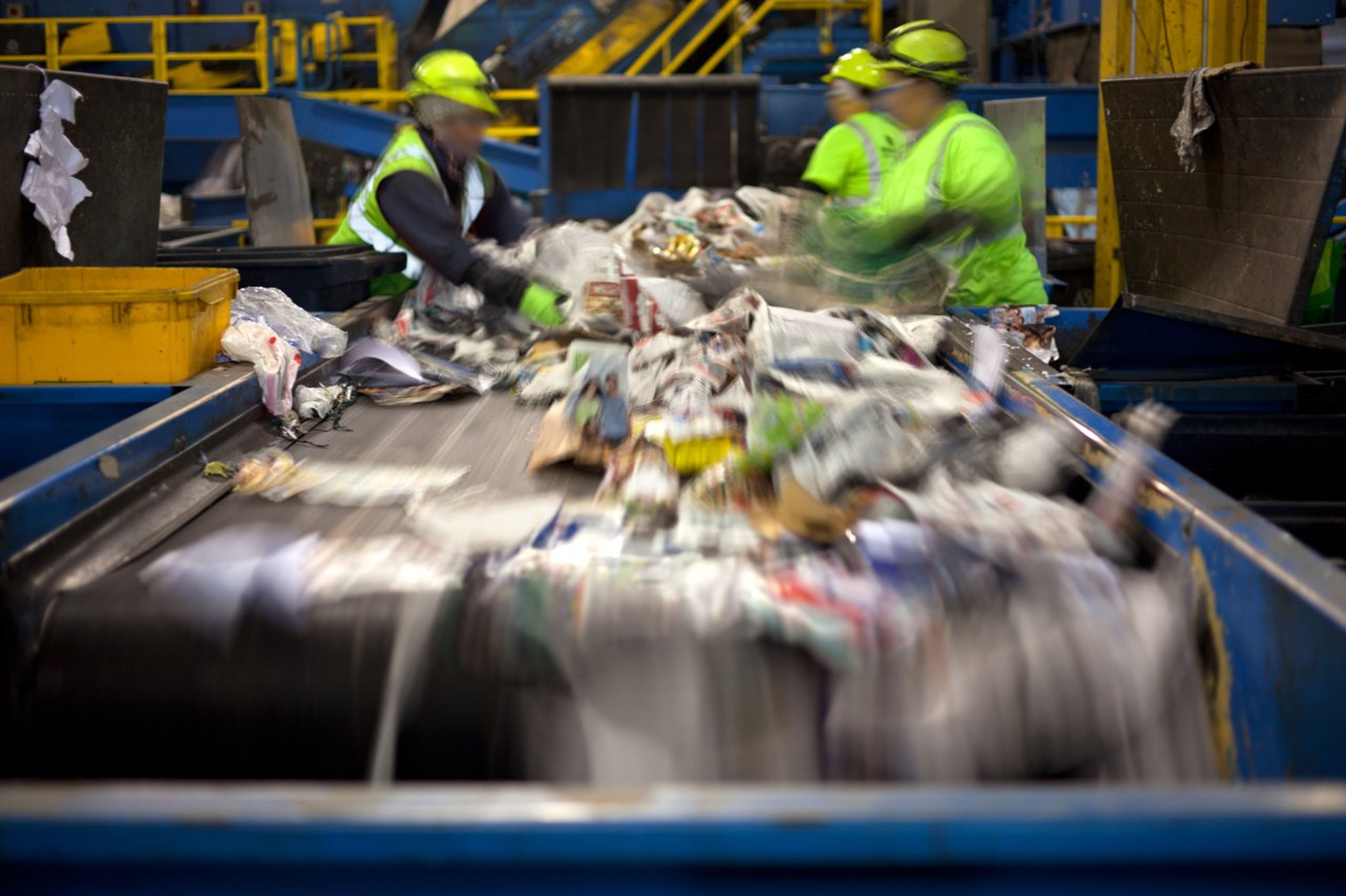 Trabajadores en una cinta de separación de residuos en una planta de reciclaje