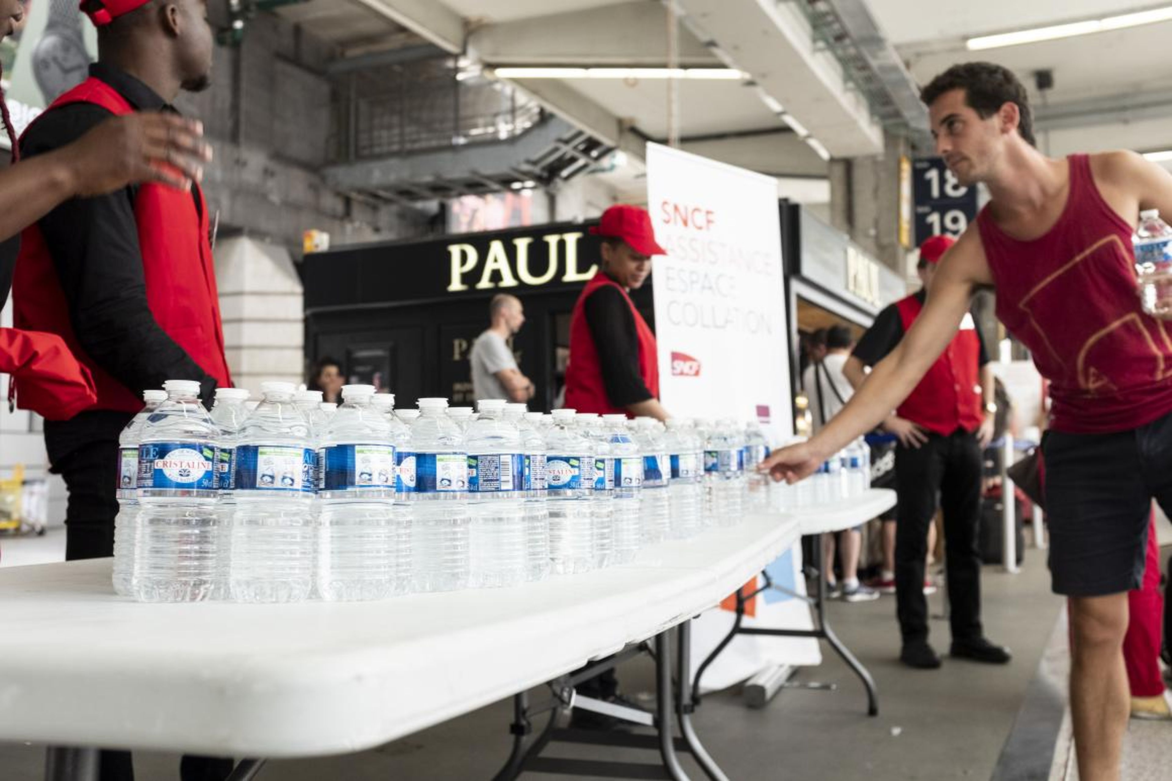 Water bottles are distributed at Paris' Montparnasse station as a heatwave hit Paris on Monday.
