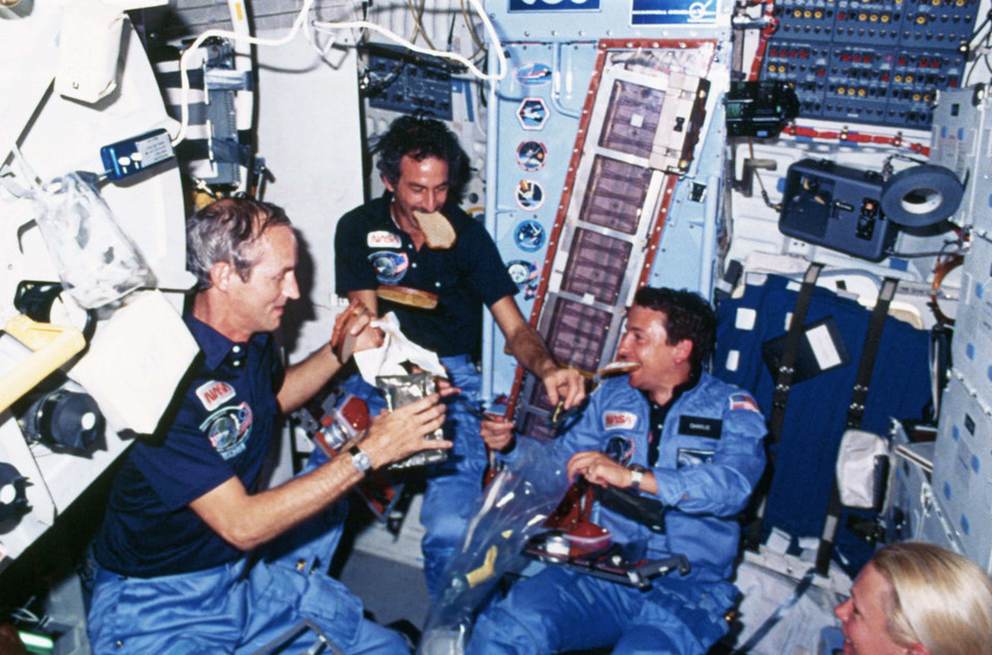 Los astronautas comen a bordo del transbordador espacial Discovery.