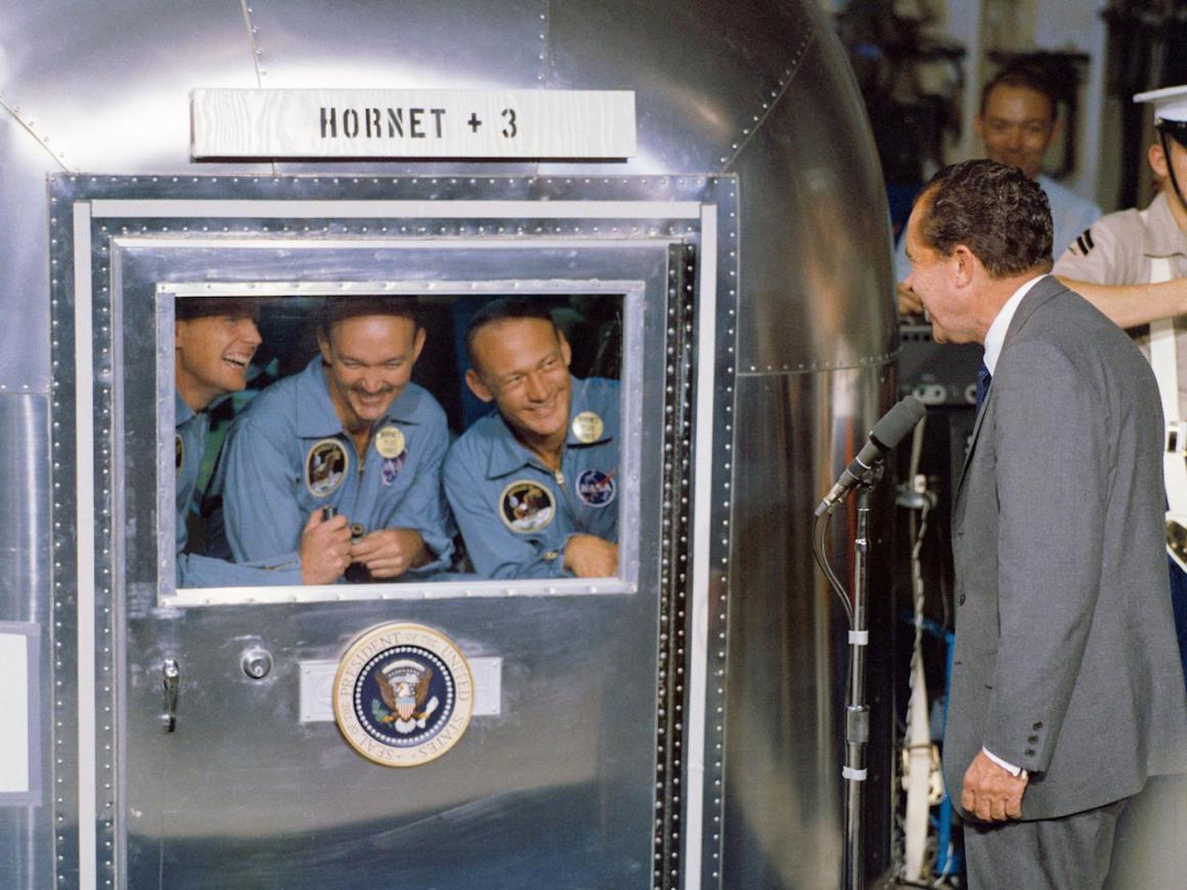 El Presidente Nixon da la bienvenida a los astronautas del Apolo 11 a bordo del USS Hornet, la nave de recuperación de la misión.