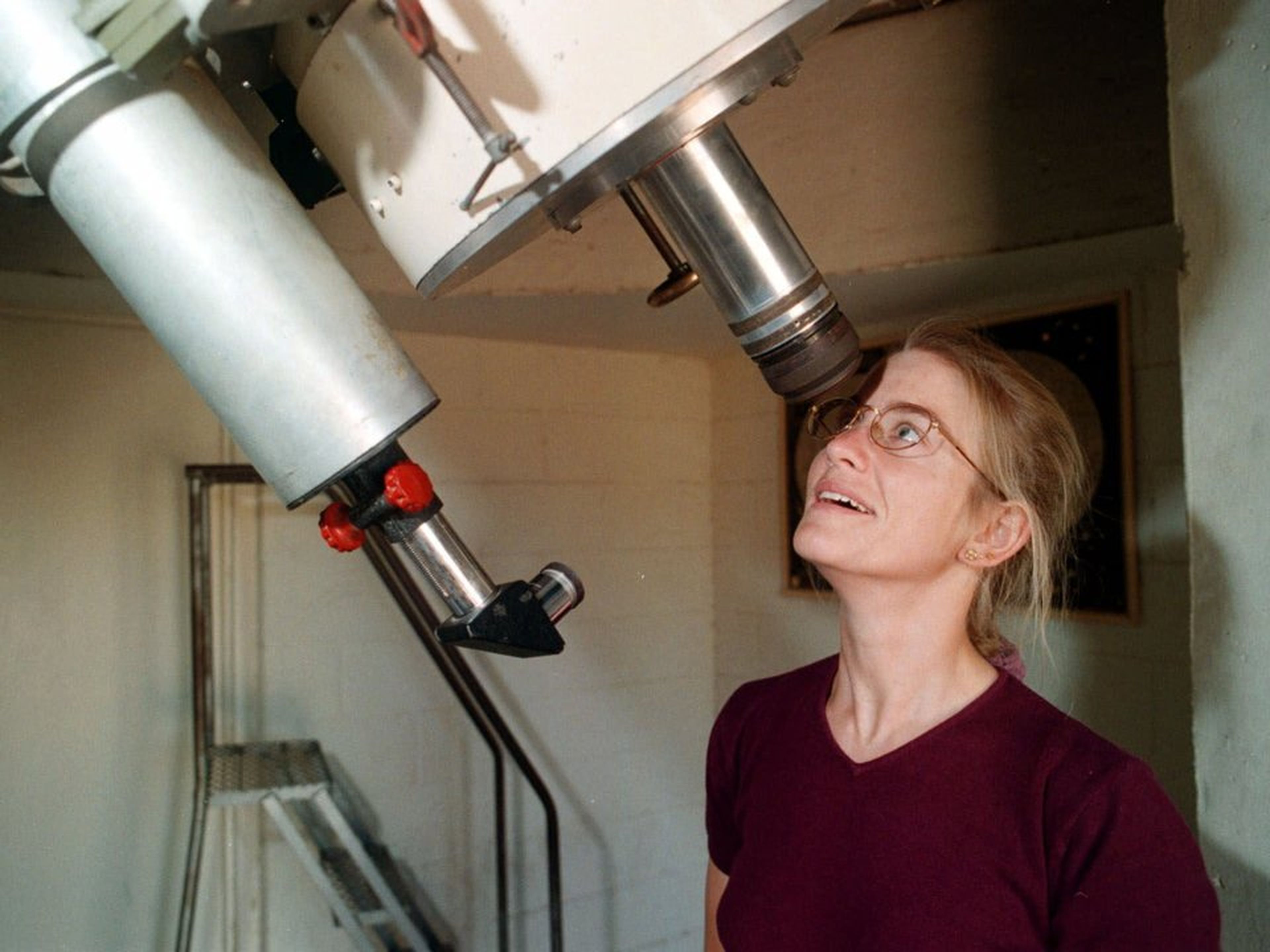 Una astrónoma mirando por un telescopio