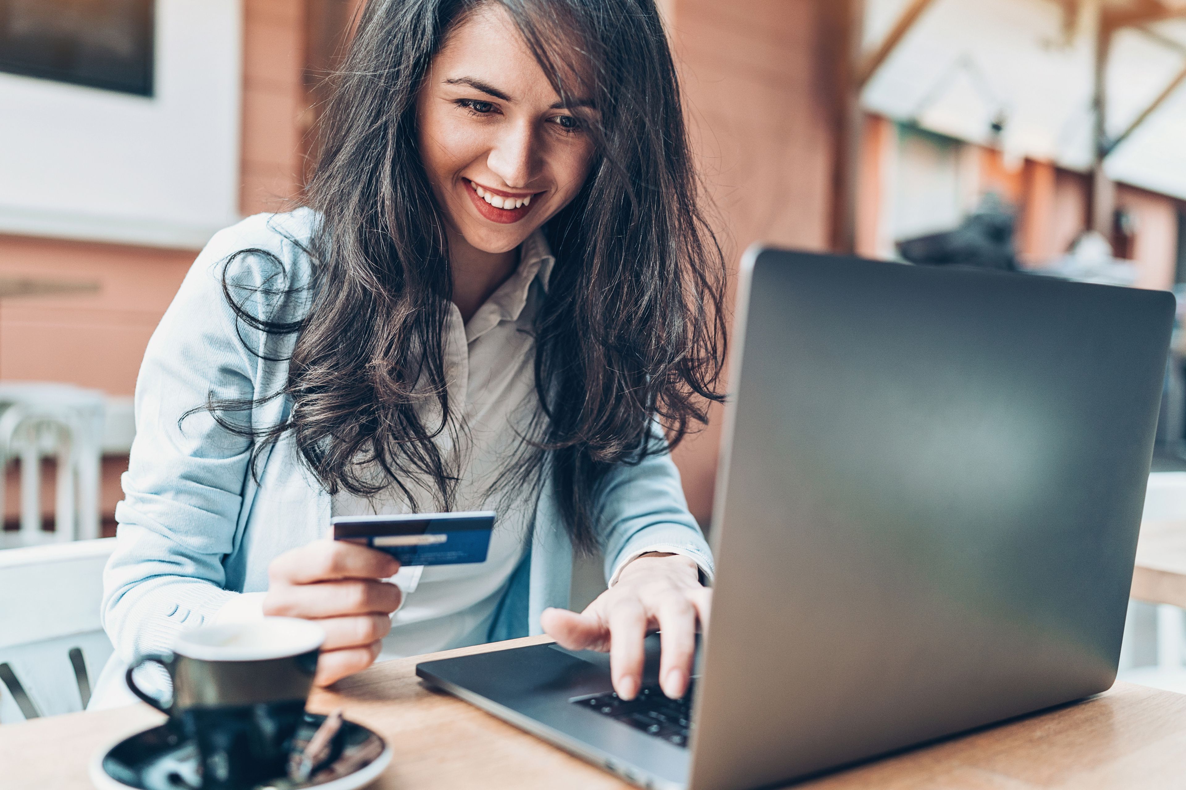 Una chica utiliza una tarjeta de crédito para hacer compras online.