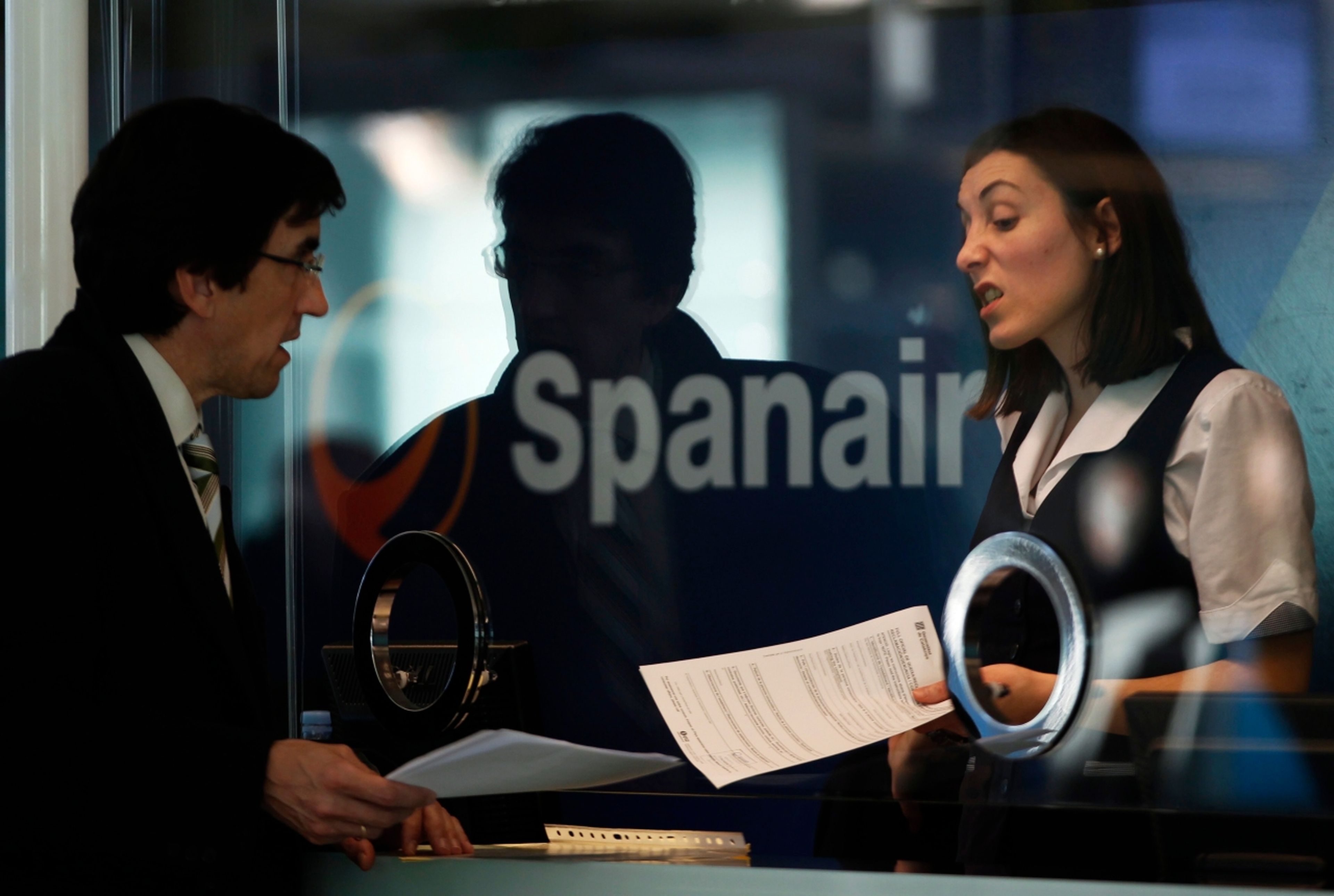 Una empleada de Spanair habla con un pasajero