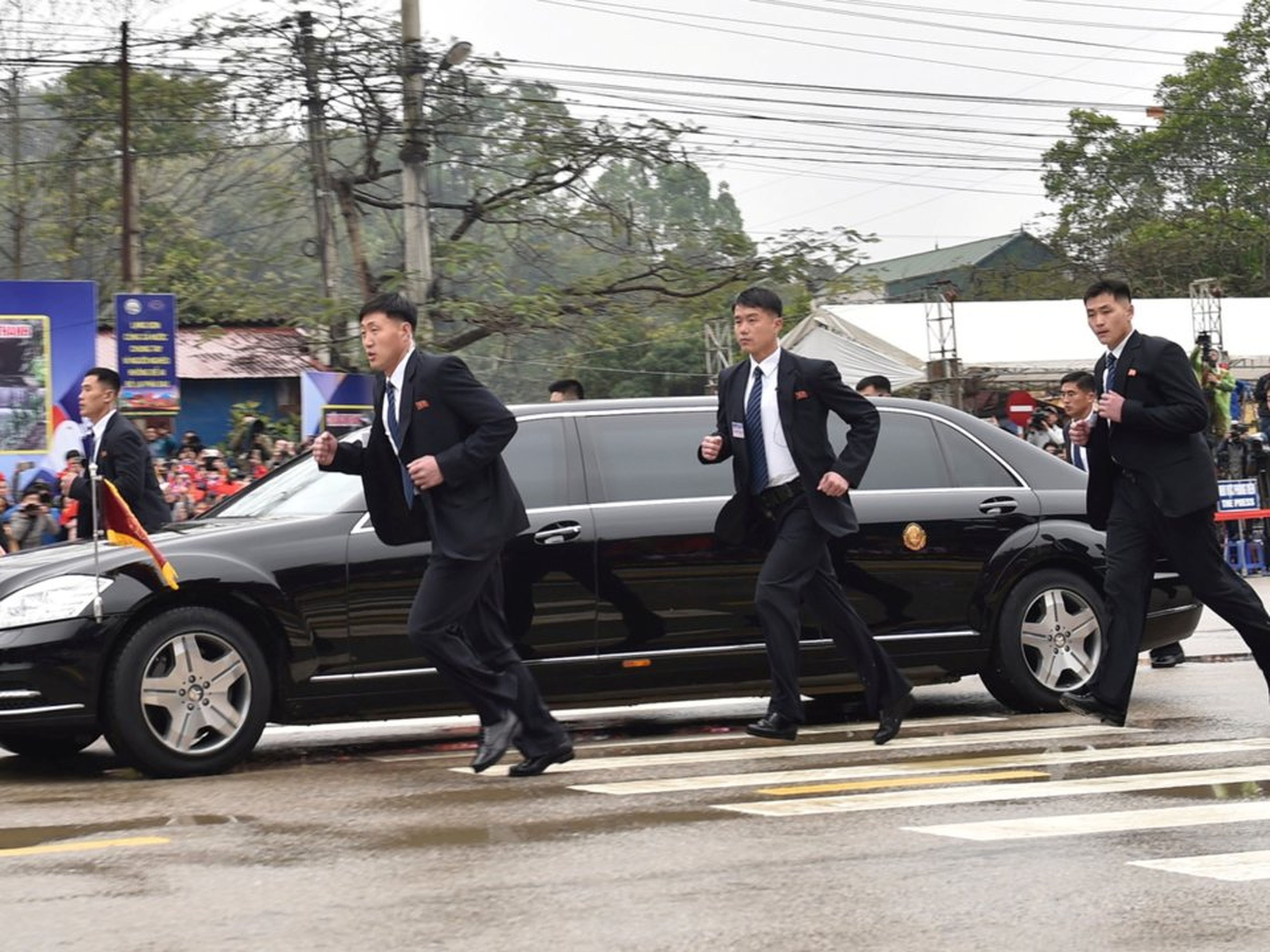 Guardaespaldas norcoreanos corriendo junto a una limusina que lleva al líder de Corea del Norte, Kim Jong Un, a su llegada a la ciudad fronteriza con China en Dong Dang, Vietnam, el 26 de febrero de 2019