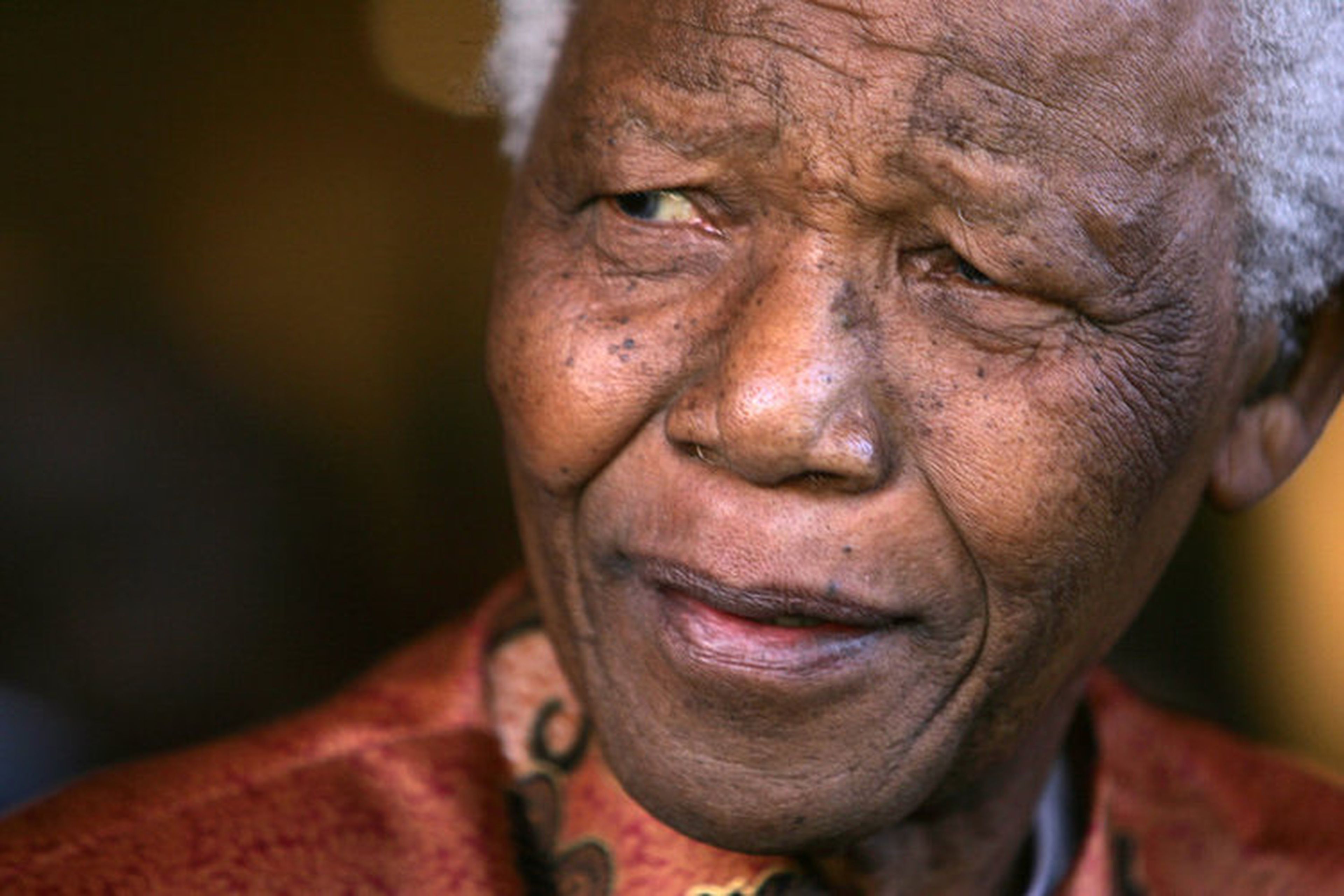 Mandela sonríe mientras anuncia formalmente su retiro de la vida pública en las oficinas de su fundación en Johannesburgo.