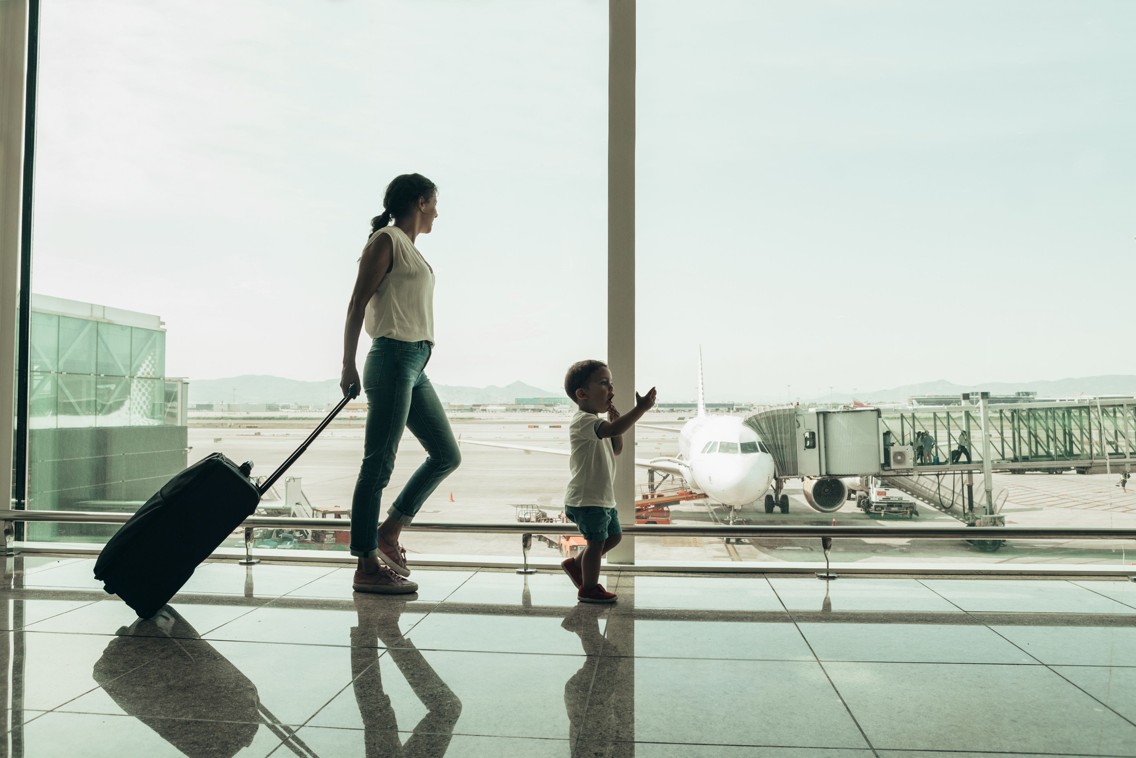 Una mujer espera con un niño en el aeropuerto.