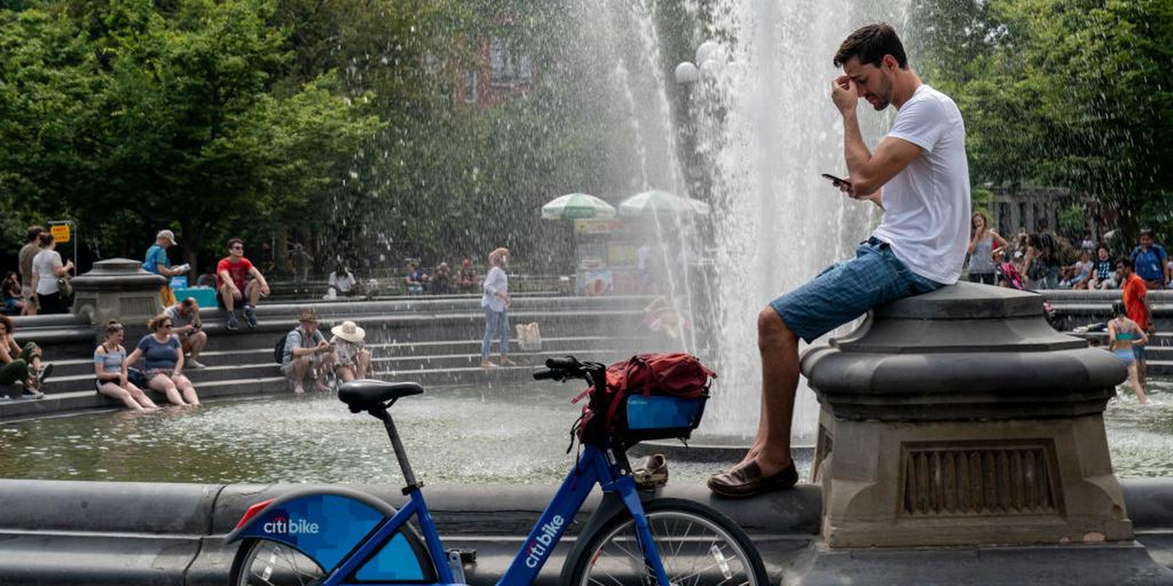 La gente se refresca cerca de la fuente en Washington Square Park durante un día caluroso de la tarde del 17 de julio de 2019 en la ciudad de Nueva York.
