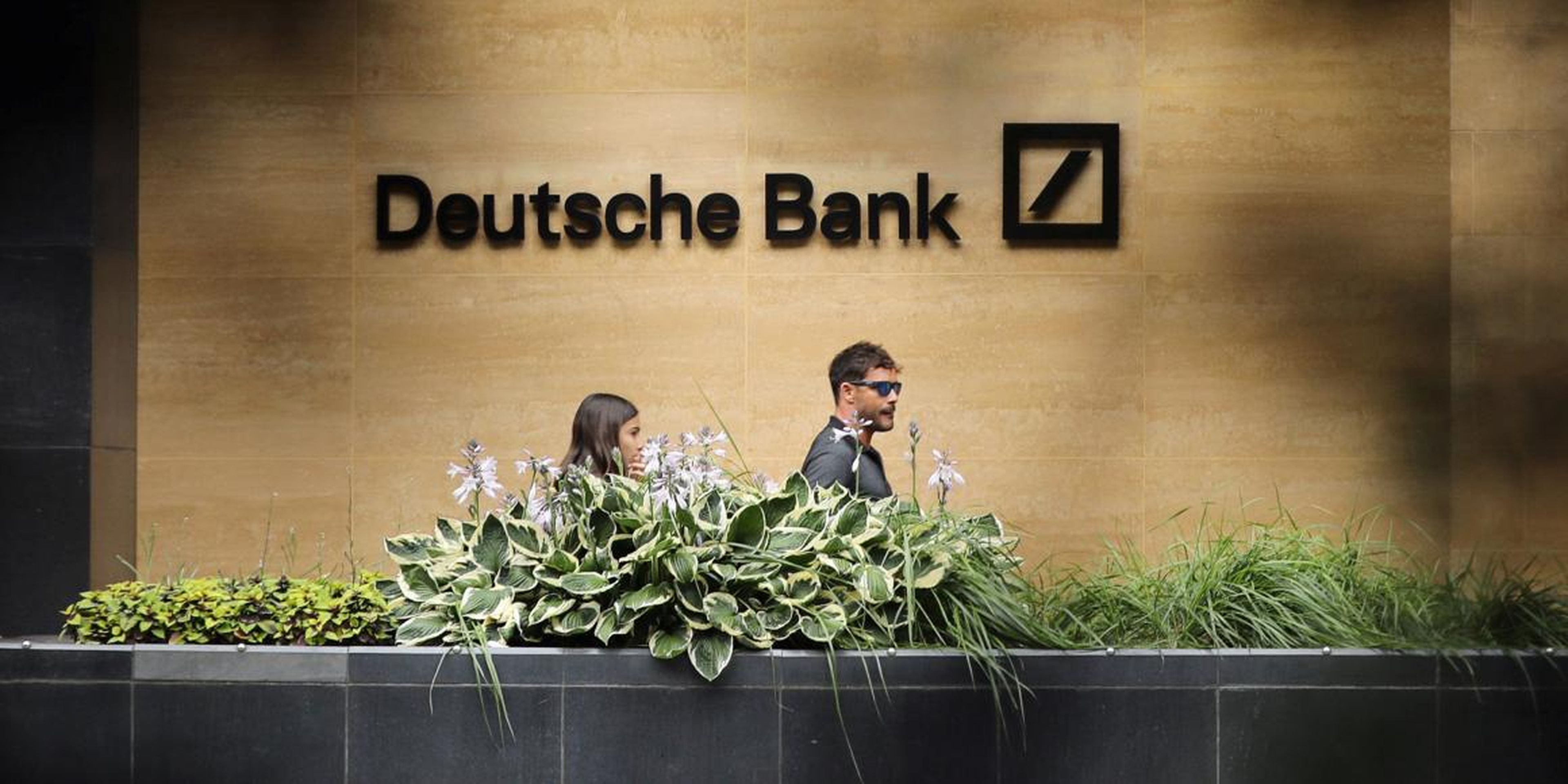 People walk past a Deutsche Bank office in London