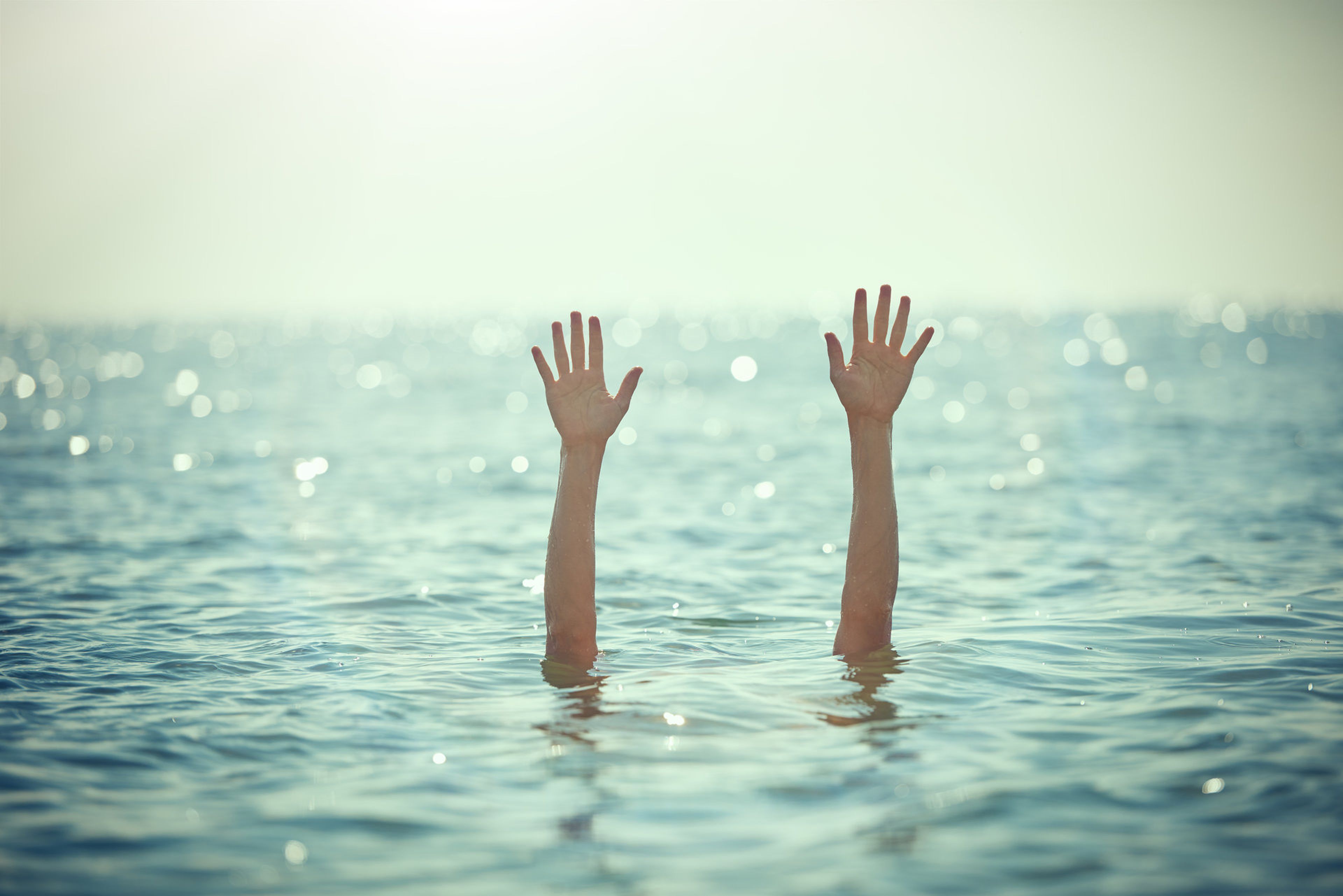 Una persona saca los brazos del mar mientras bucea