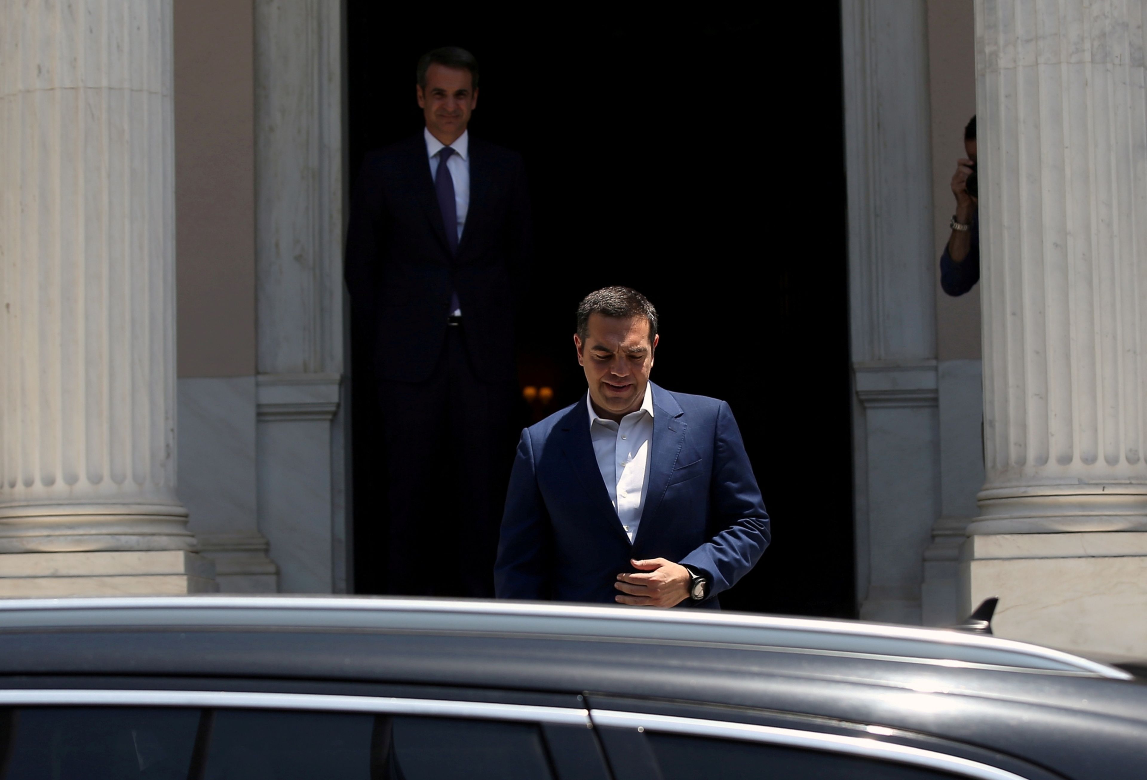 En primer plano, el primer ministro saliente de Grecia, Alexis Tsipras, y de fondo su sucesor, Kyriakos Mitsotakis