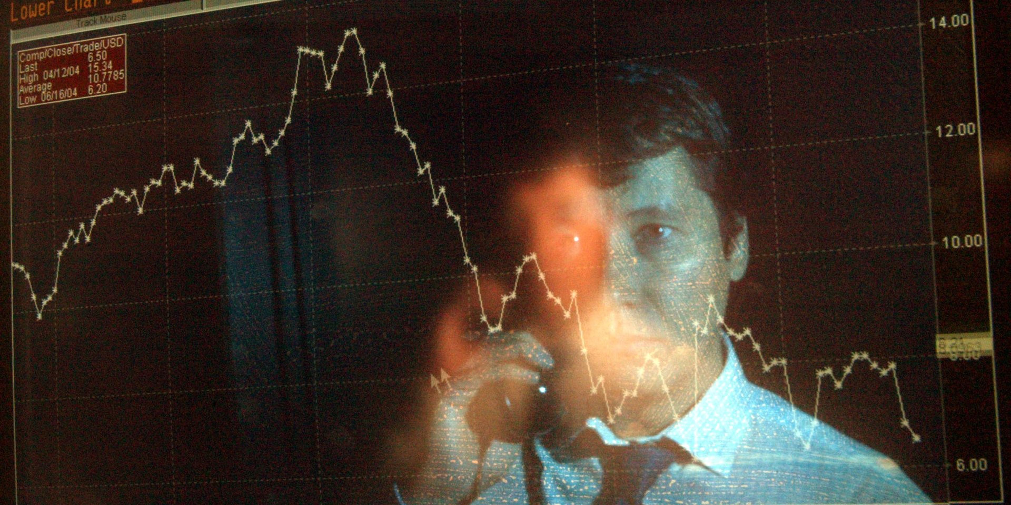 El reflejo de un trader en una pantalla en la que se ven caídas en bolsa