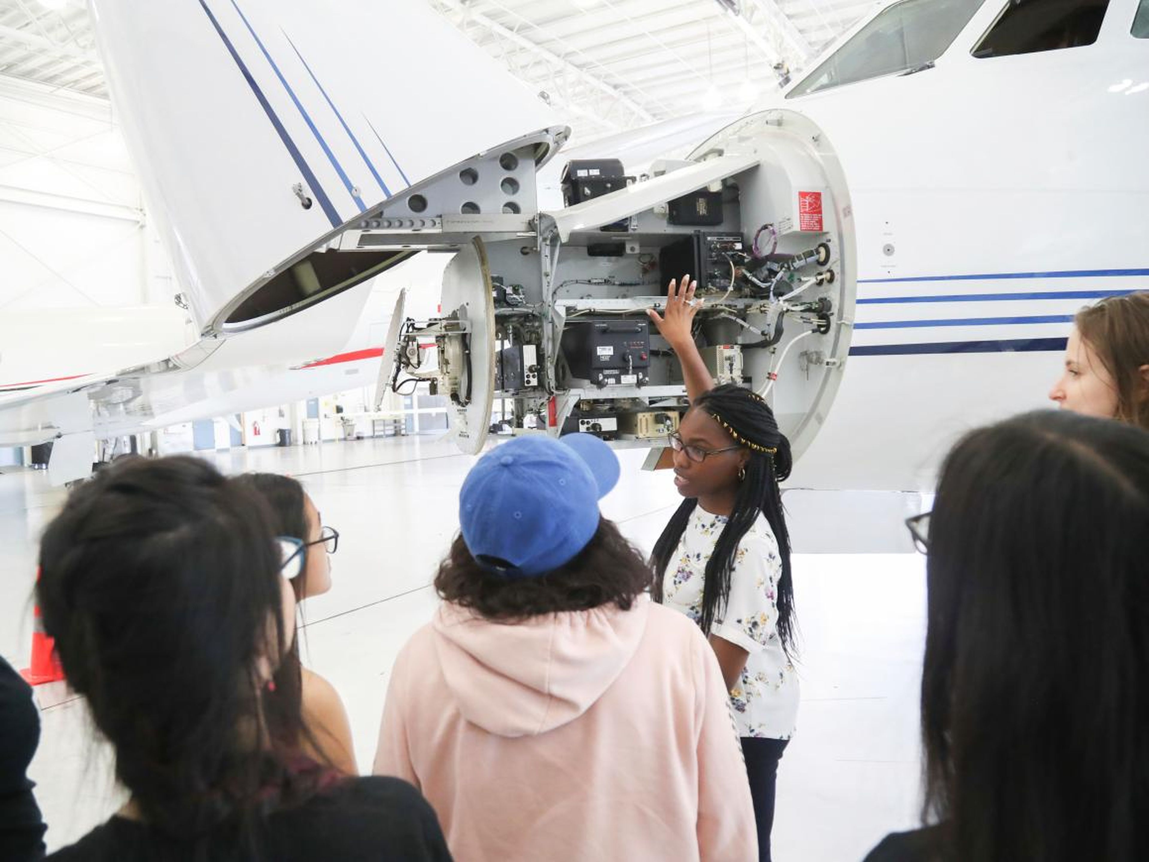 La ingeniera aeroespacial Tina Oyeniya explica la tecnología dentro de un avión a las alumnas de Girls Who Code.