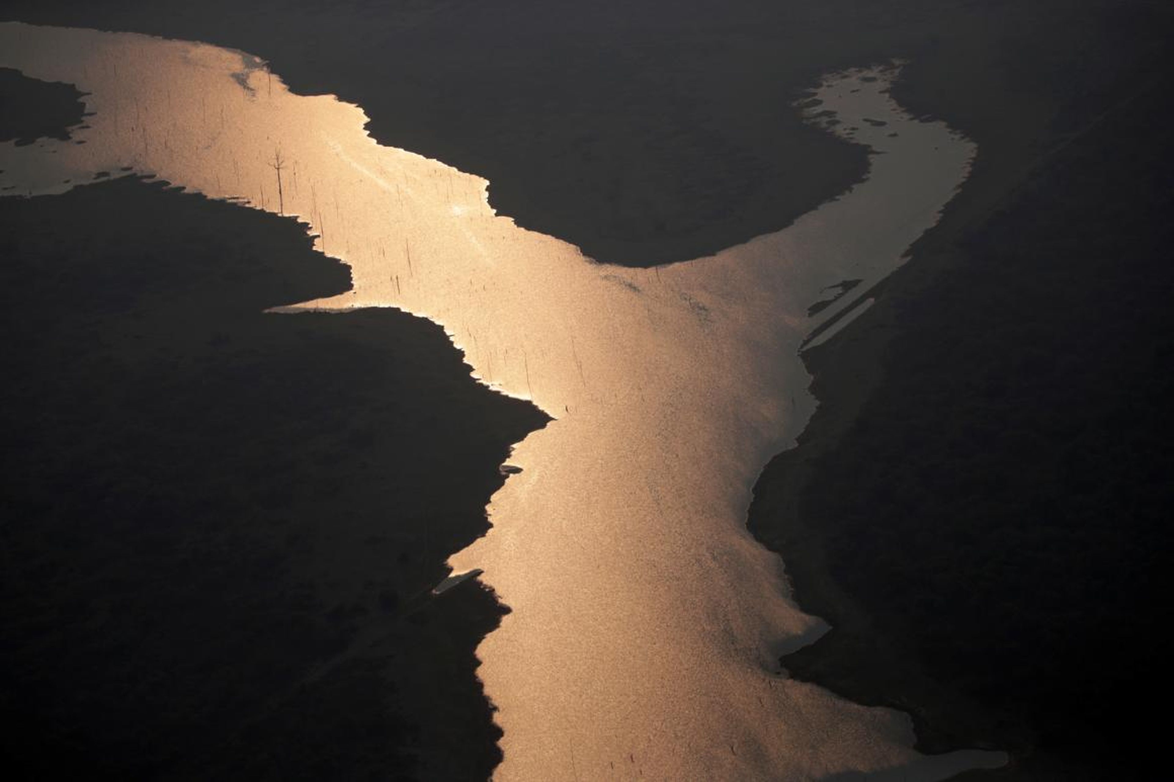 La luz del sol se refleja en el lago de la presa hidroeléctrica Samuel, en un área de la selva amazónica cerca de Porto Velho, el 21 de agosto de 2019.