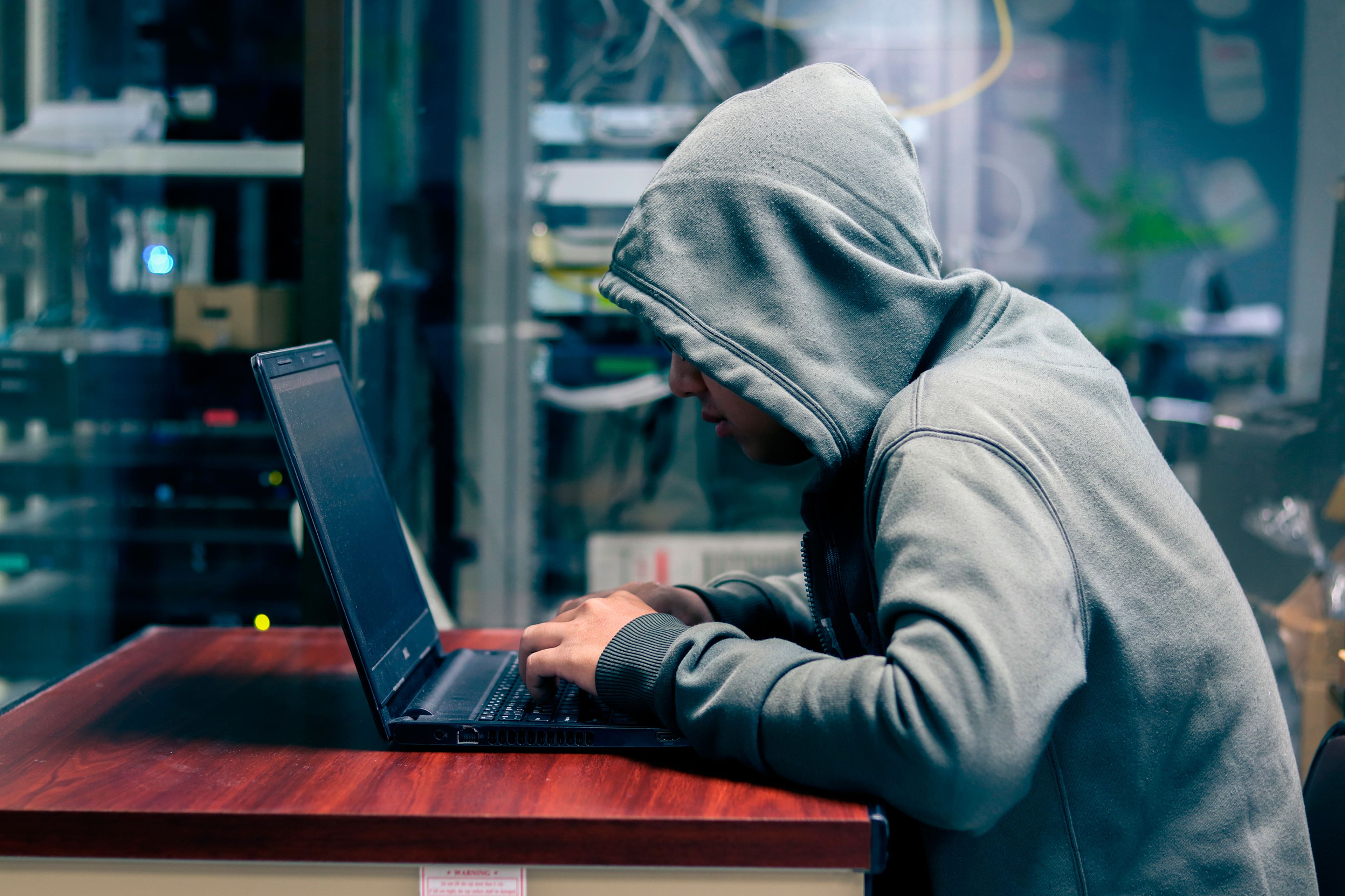 Un hacker frente a la pantalla de un ordenador portátil