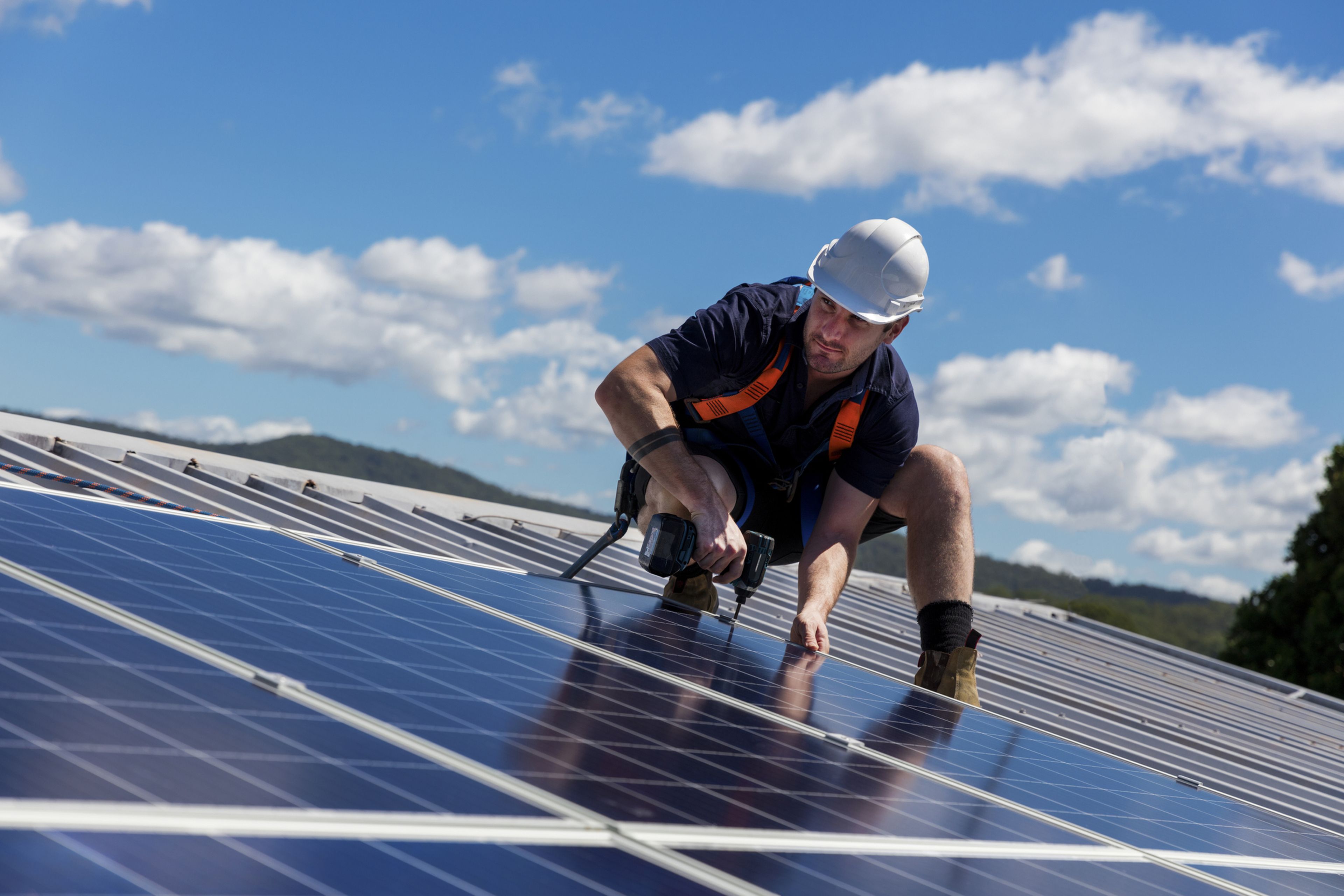 Hombre instalando paneles solares en el tejado