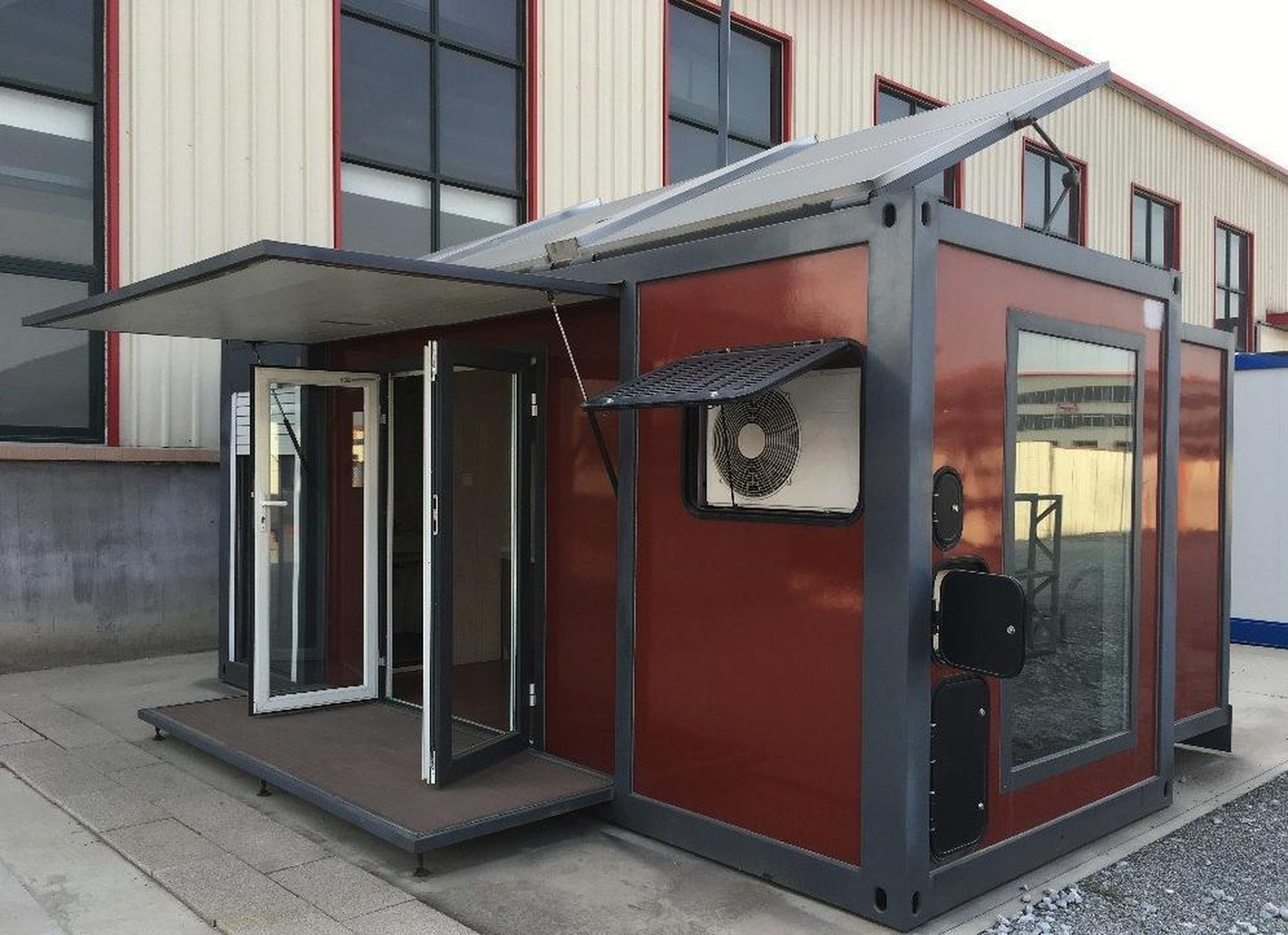 The module container house expands with a remote control. It features a folding deck and a canopy, and solar panels can be seen on the roof.