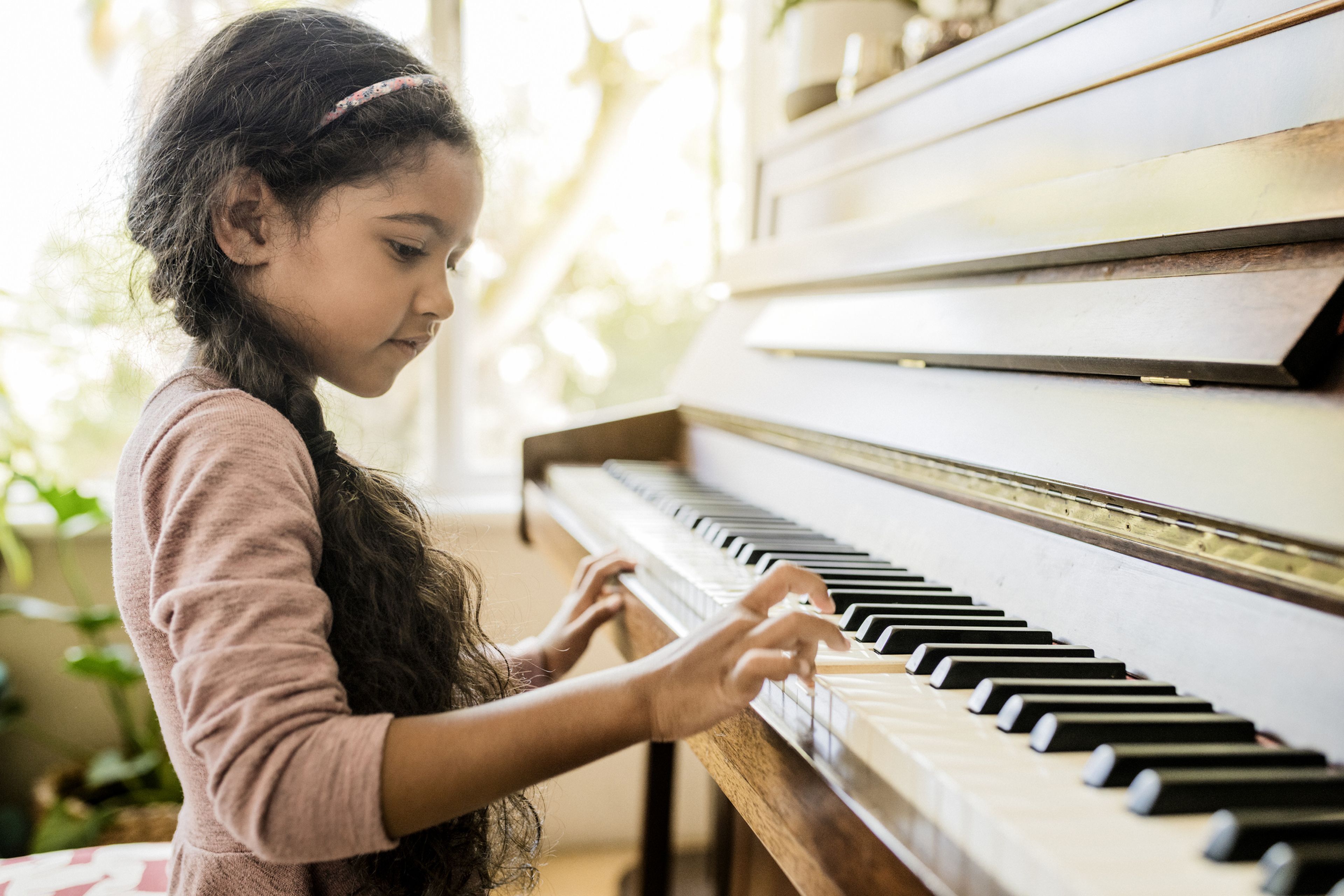 Una niña aprende a tocar el piano.