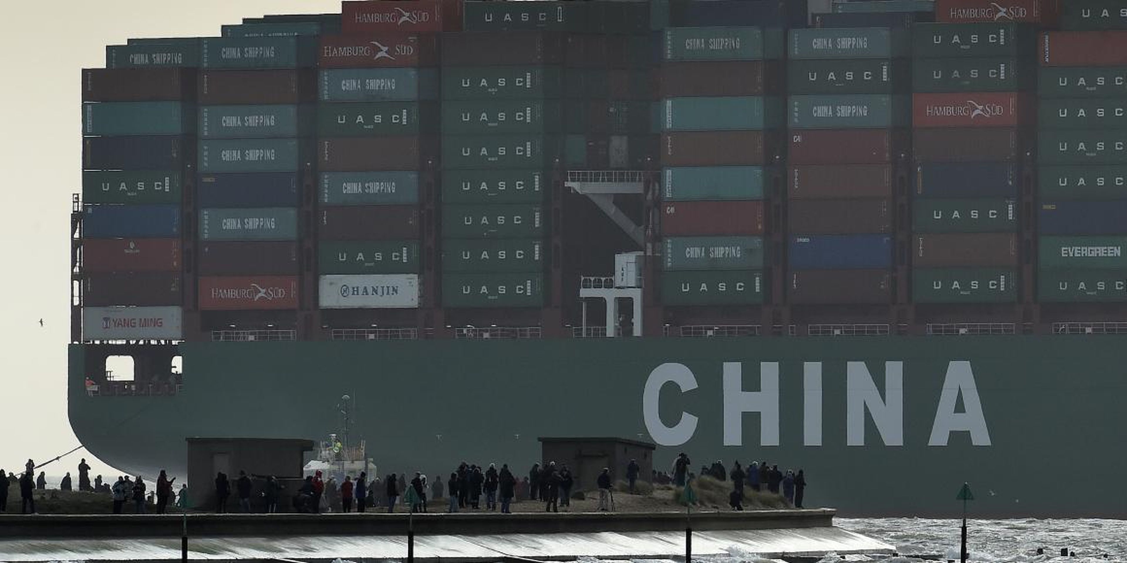 Onlookers watch from a harbor wall as the largest container ship in world, CSCL Globe, docks during its maiden voyage, at the port of Felixstowe in south east England, Jan. 7, 2015.