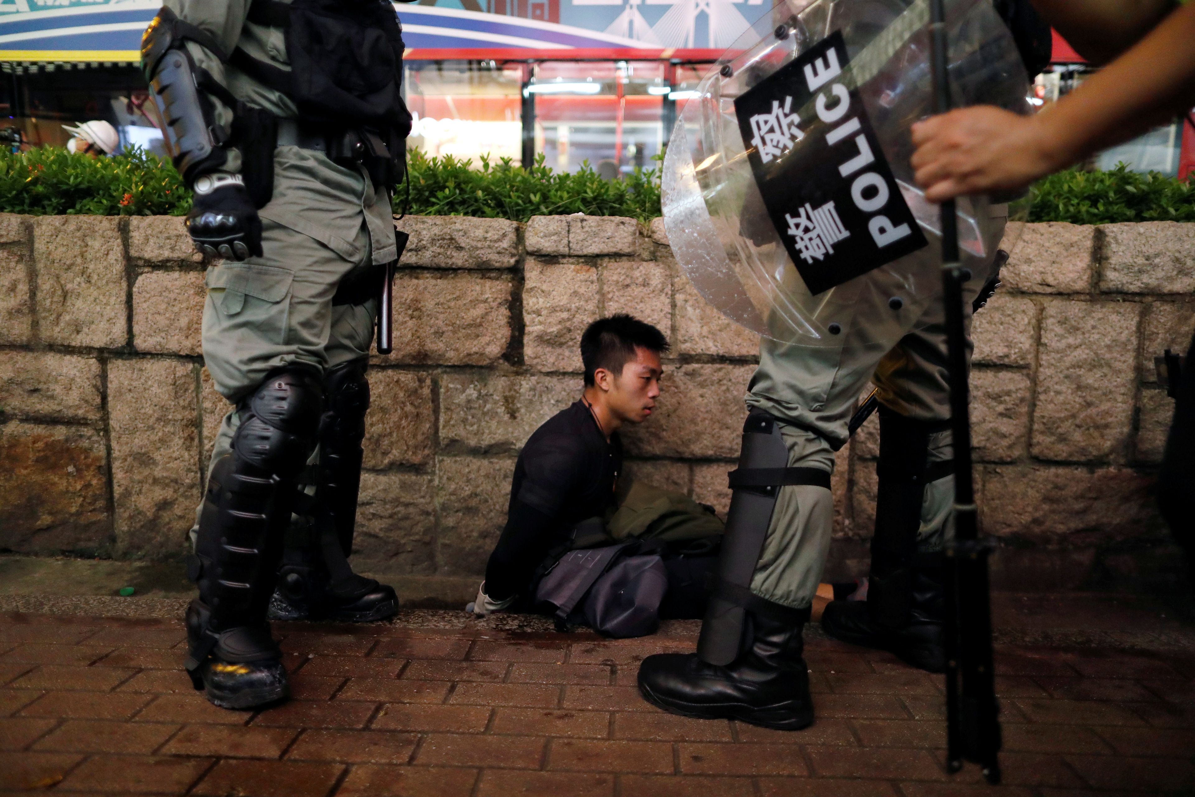 Policías antidisturbios detienen a un manifestante en el barrio de Tsim Sha Tsui, en Hong Kong.