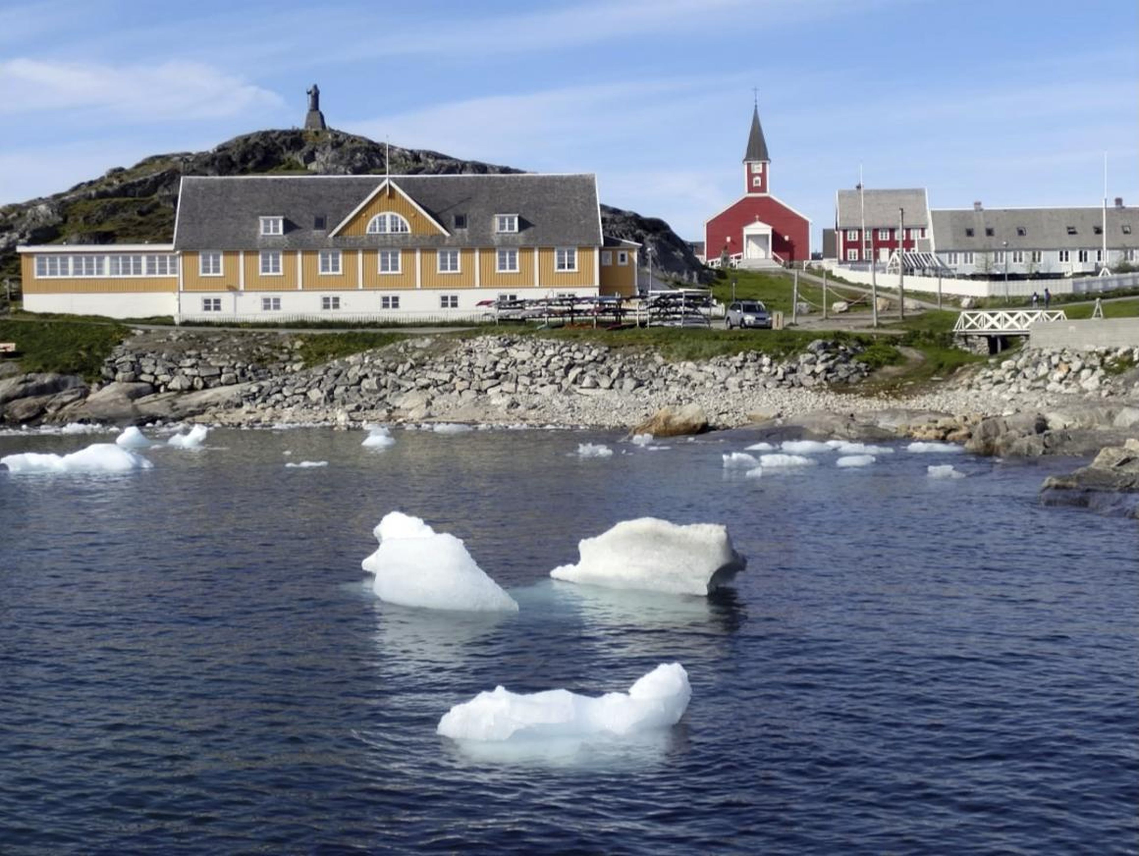 Small pieces of ice float in the water off the shore in Nuuk, Greenland on June 13, 2019.