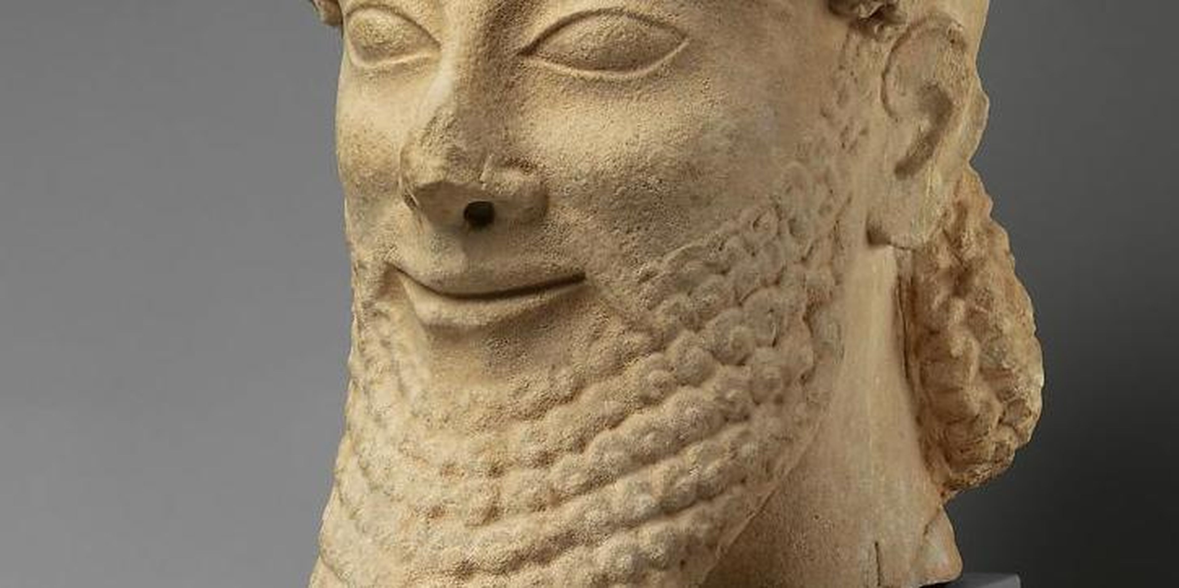 A smiling limestone male head from the last quarter of the 6th century BC.