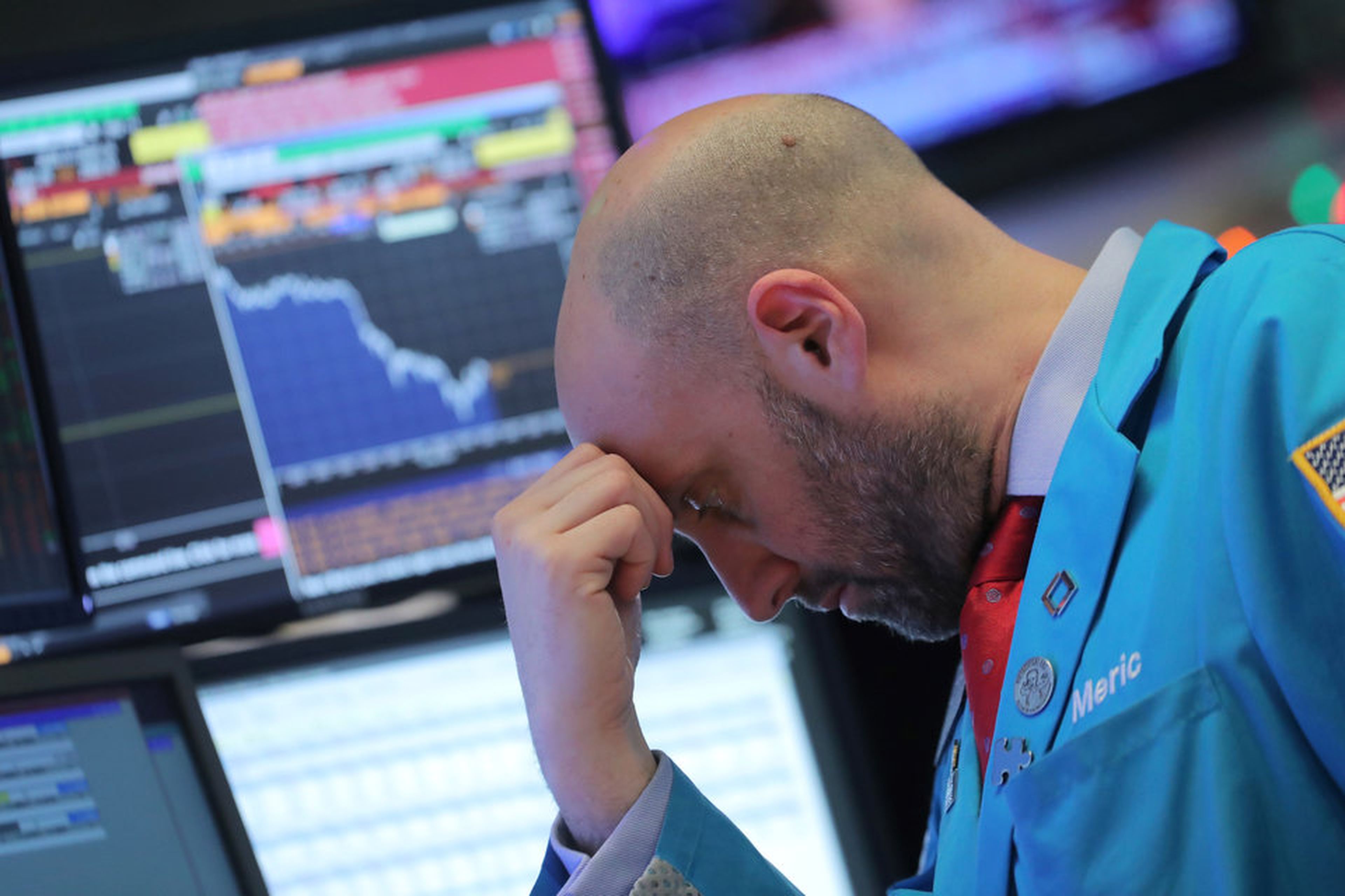 Un trader de Wall Street, con rostro preocupado ante las pantallas de bolsa