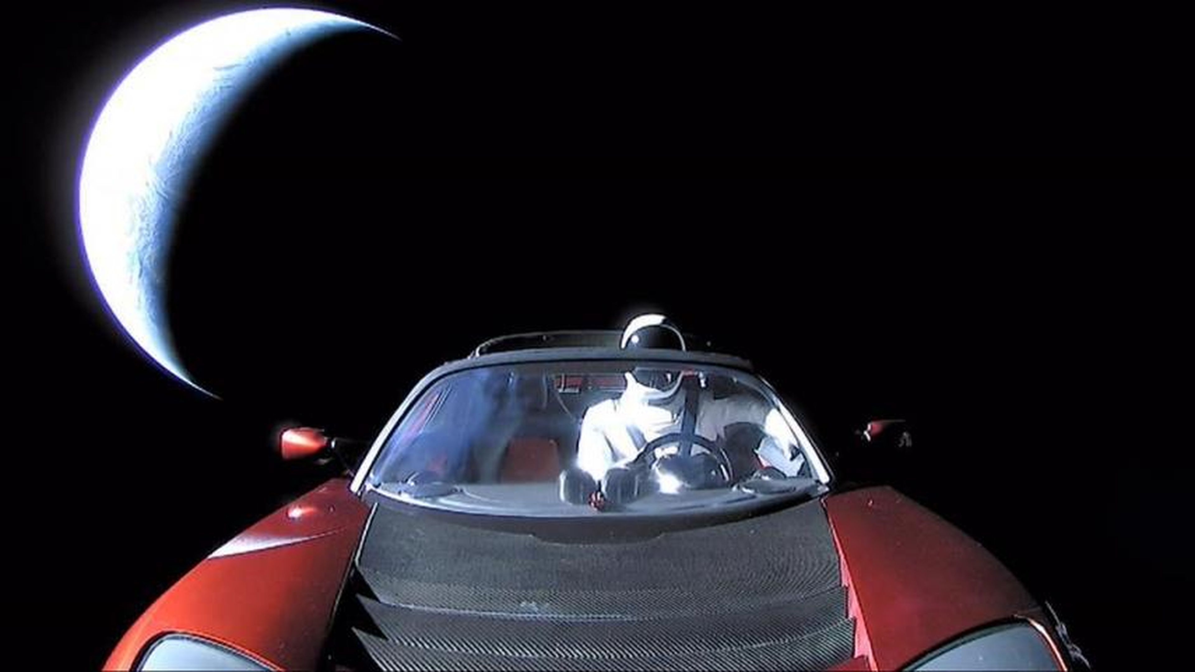 La última foto de "Starman" en el Tesla Roadster rojo de Elon Musk mientras vuela hacia la órbita de Marte. La Tierra es la media luna brillante vista en el fondo.