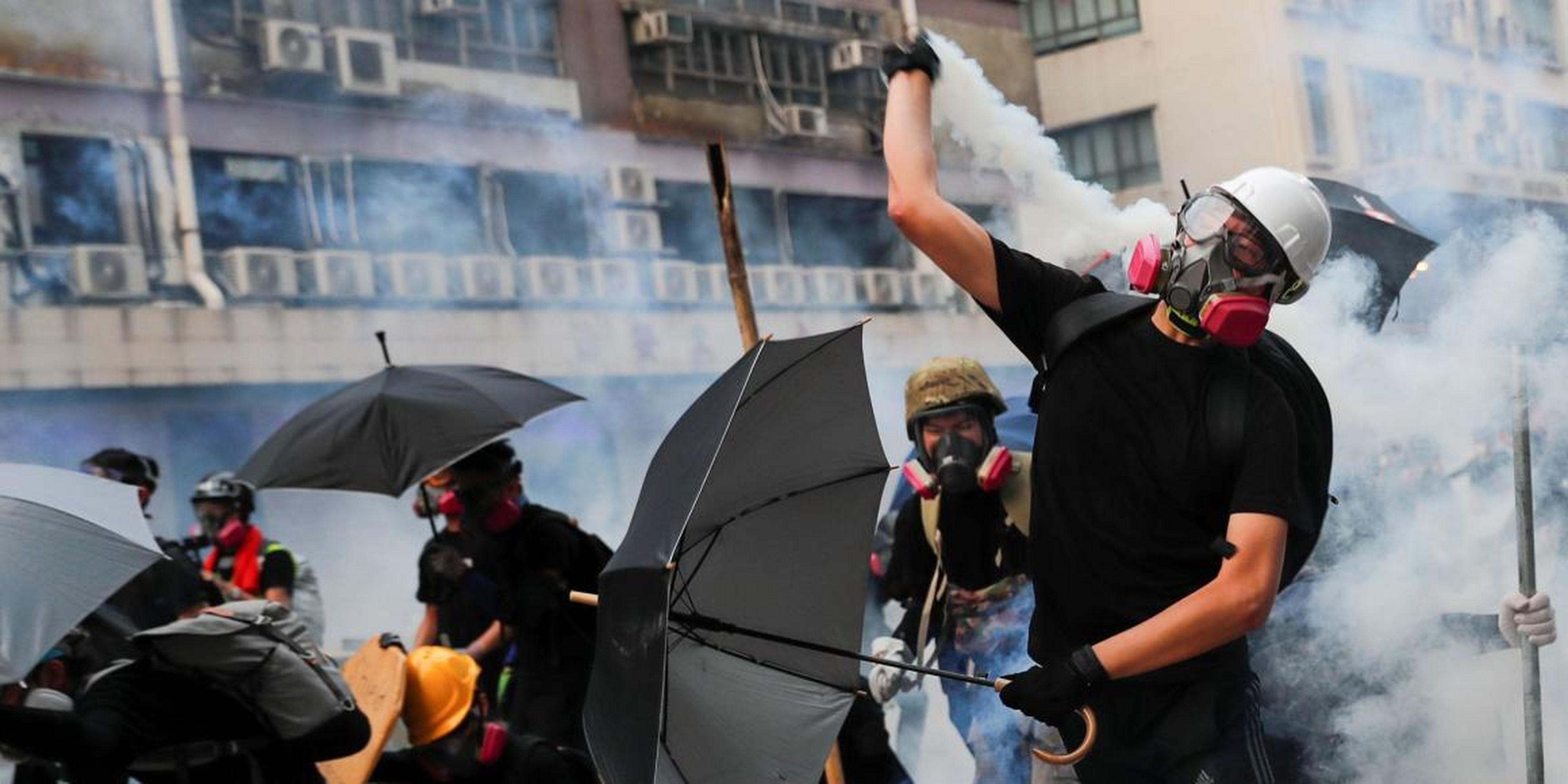 A demonstrator throws back a tear gas canister as they clash with riot police during a protest in Hong Kong, China, August 24, 2019.