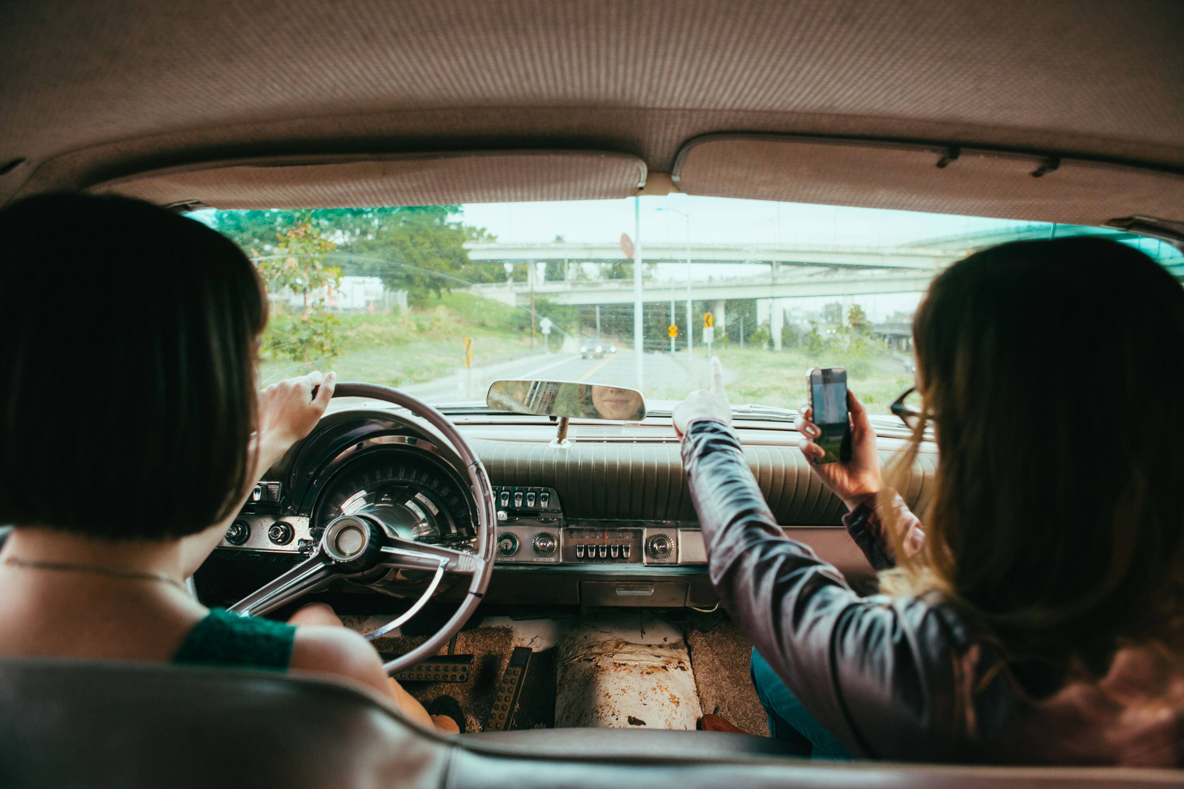 Dos mujeres conduciendo un coche vintage