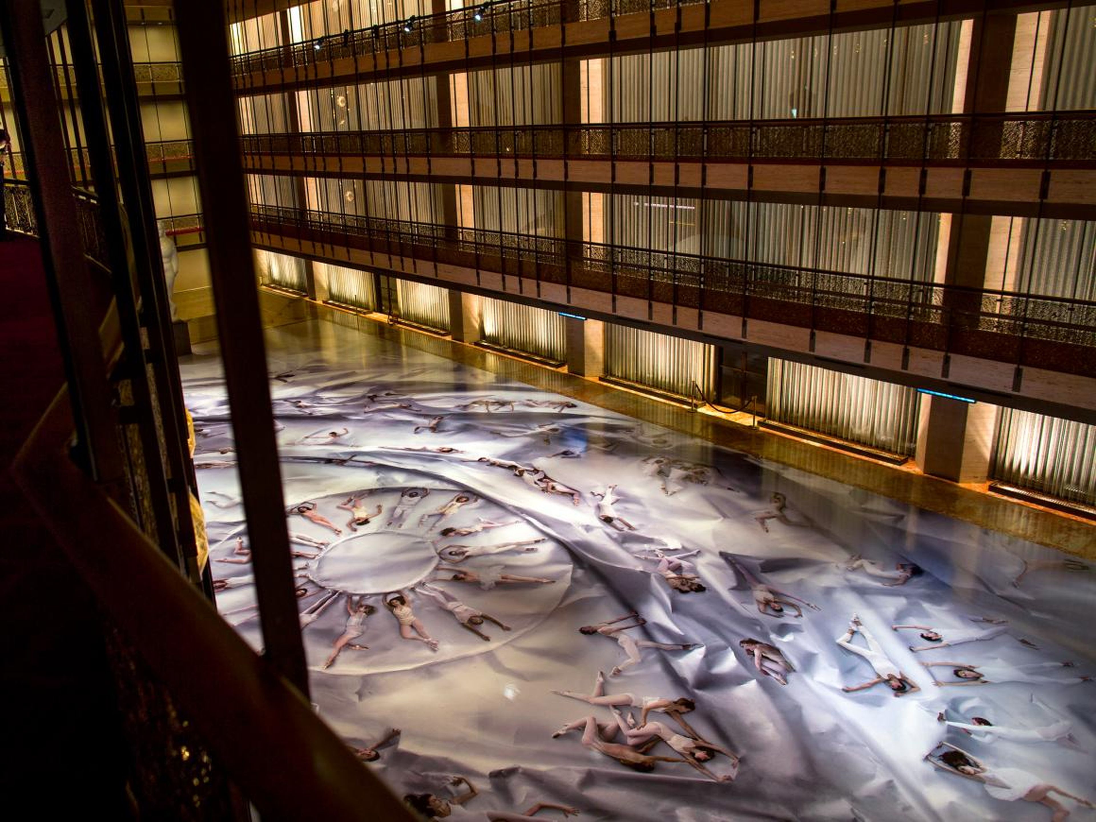 Los clientes del Ballet de la ciudad de Nueva York, a la izquierda, observan una fotografía masiva sobre pisos de linóleo en el Lincoln Center en 2014.