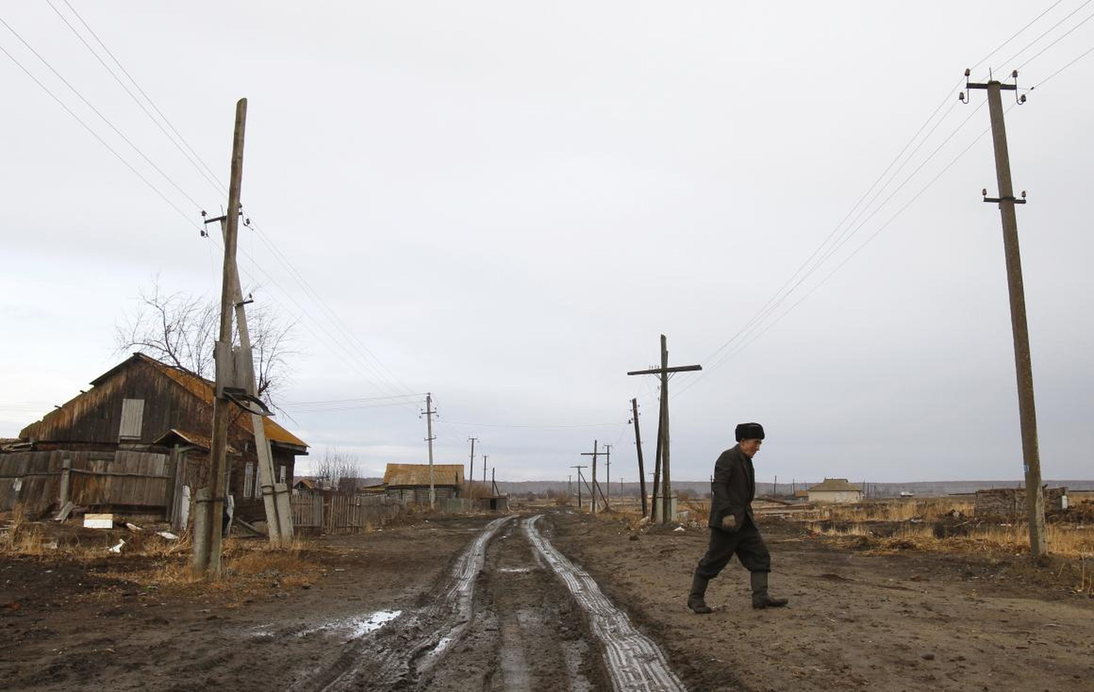 Un hombre camina junto a su antigua casa en el pueblo de Muslyumovo el 17 de noviembre de 2010.