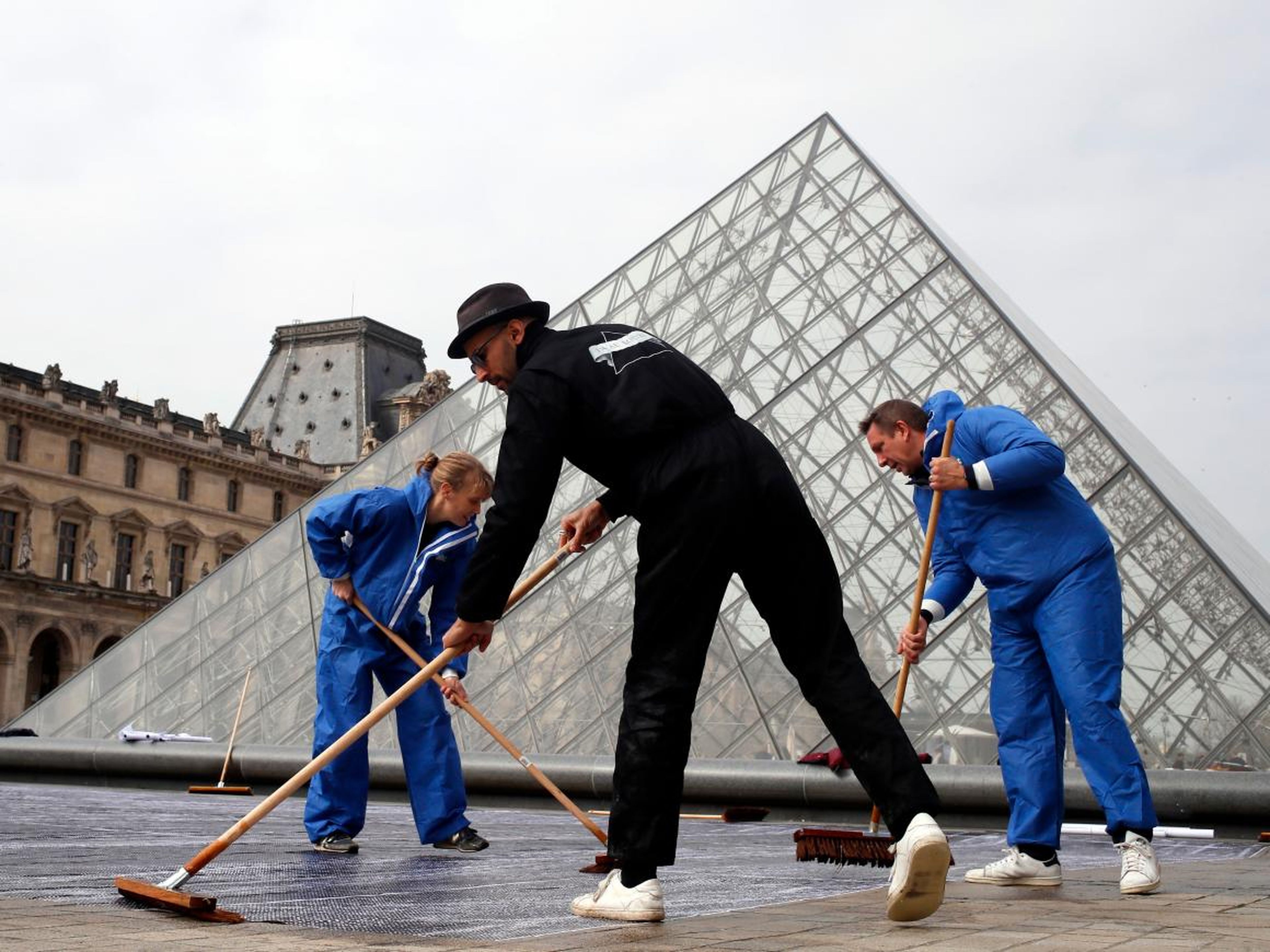 JR trabaja frente al Louvre en 2019.