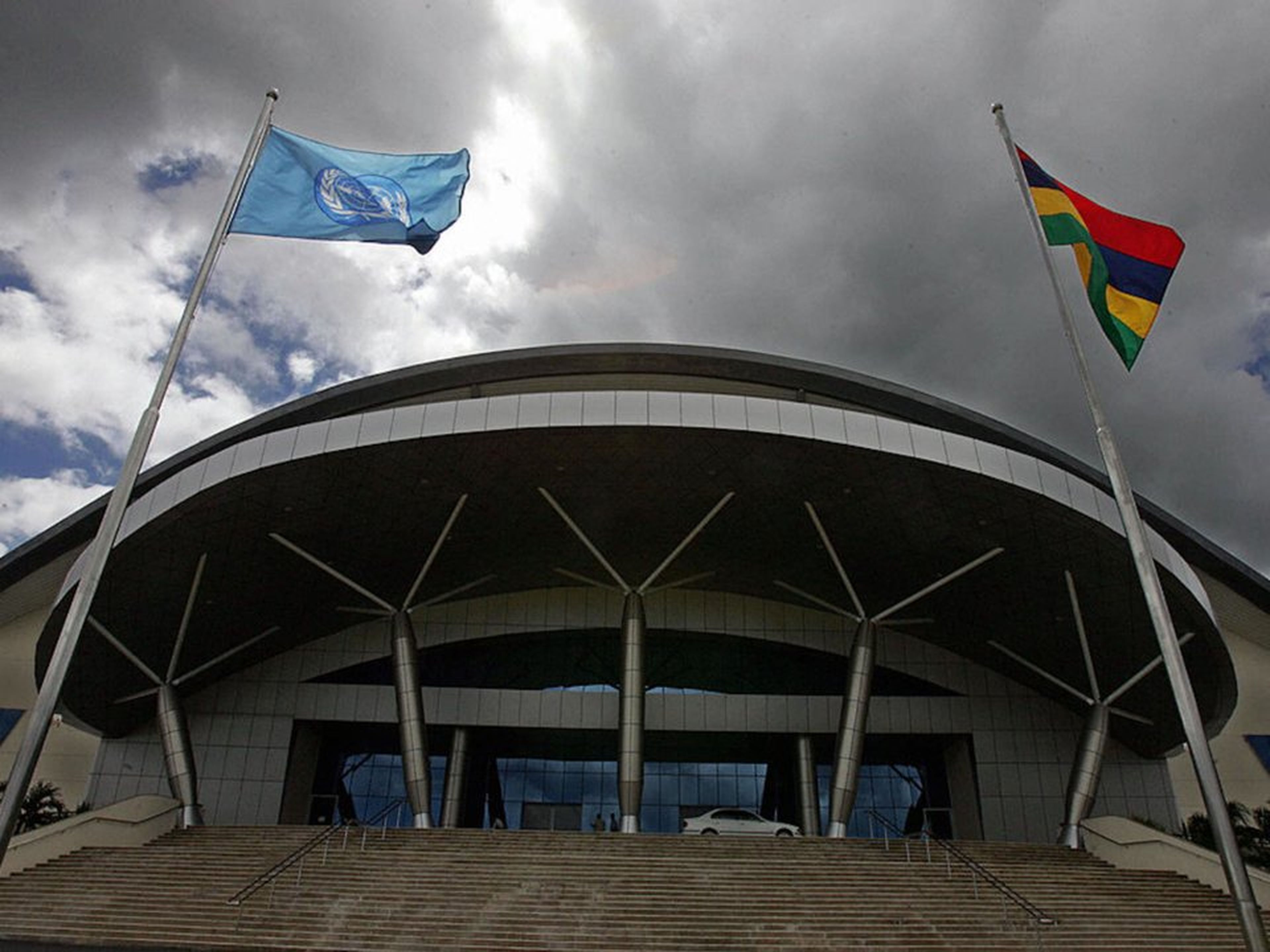 Un centro de conferencias en Port Louis, Mauricio, con las banderas de las Naciones Unidas y Mauricio.