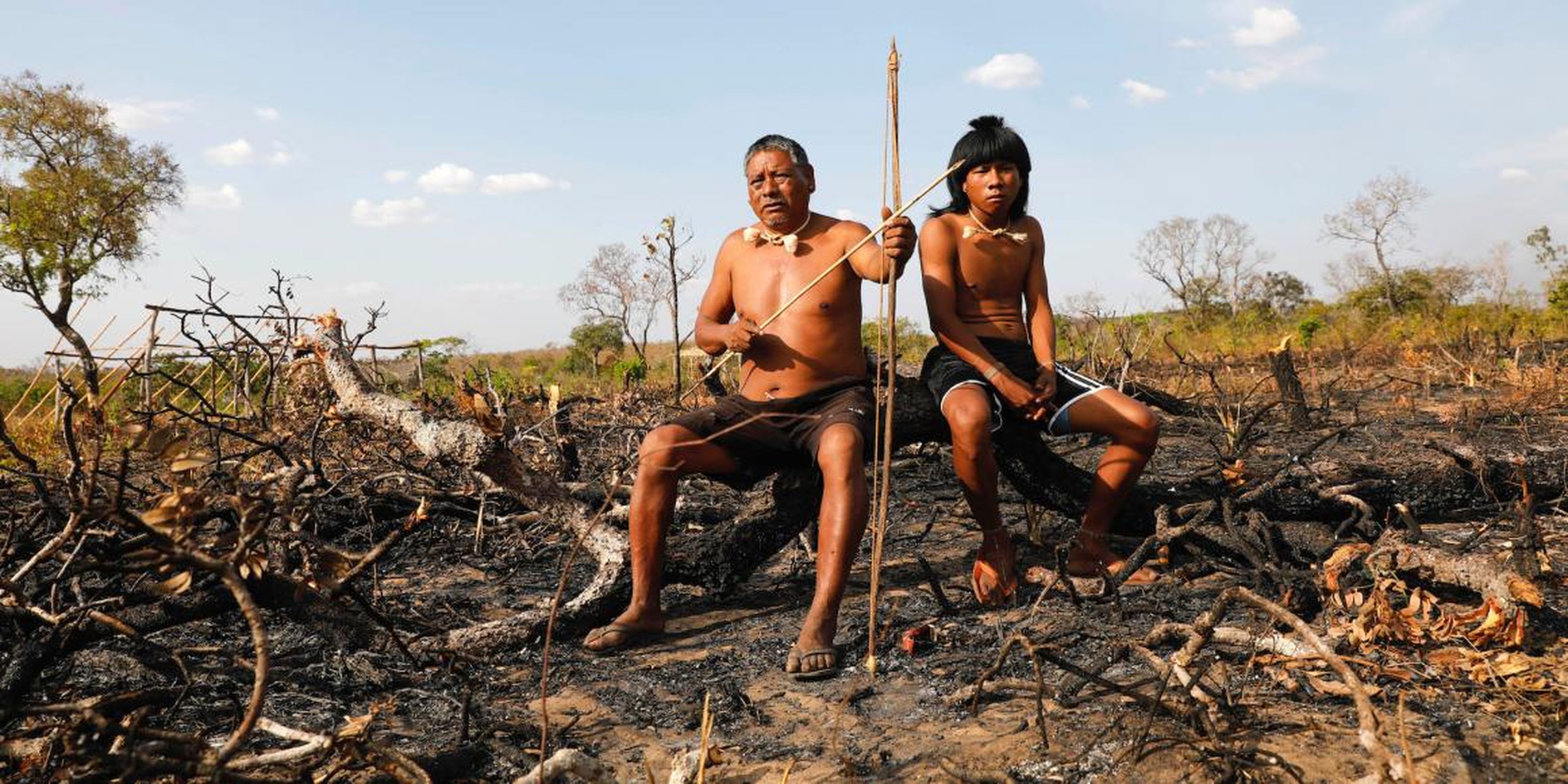 Los miembros de la tribu Xavante se sientan en ramas carbonizadas en la selva amazónica.