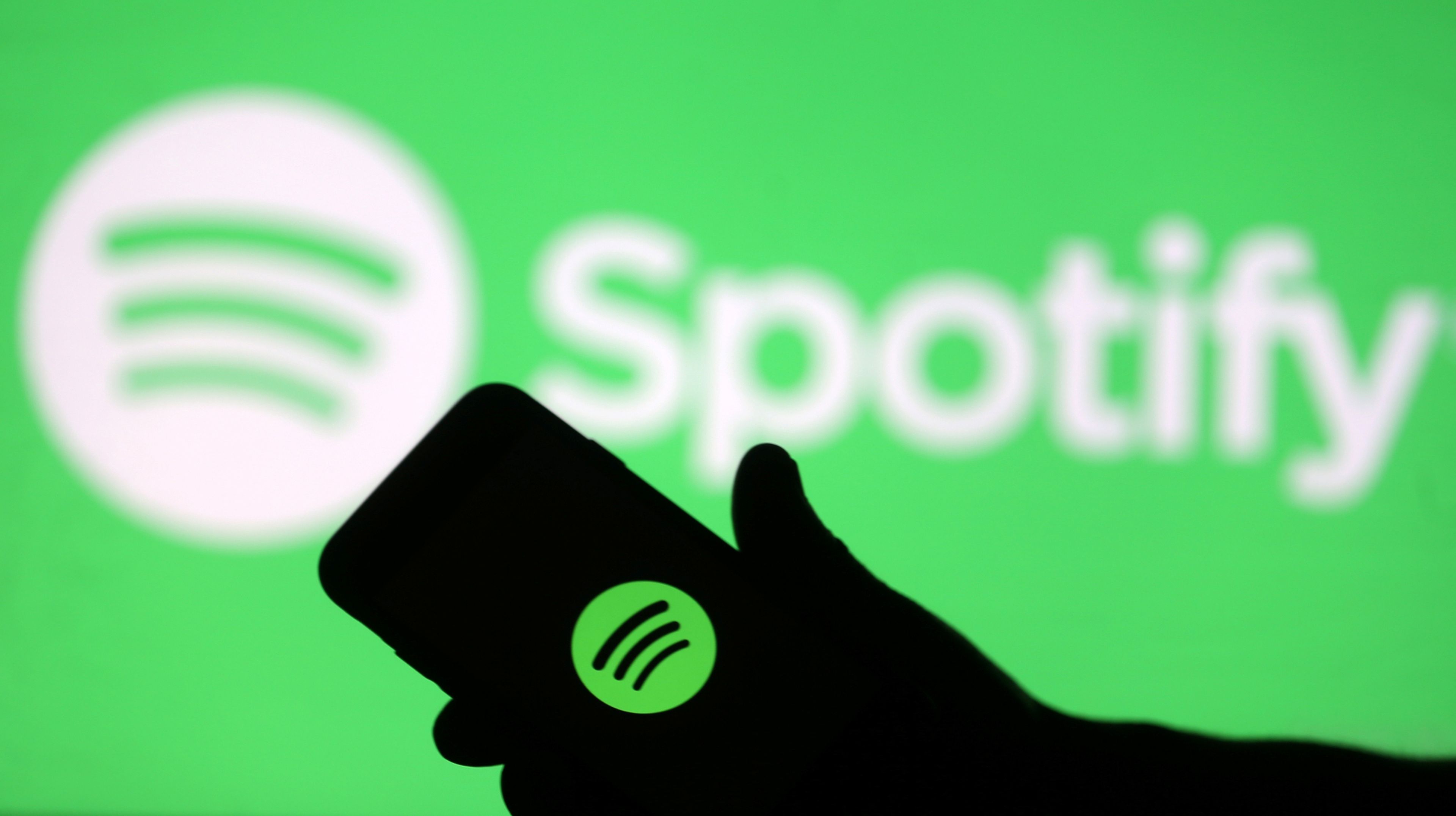 Un móvil con el logotipo de Spotify ante un anuncio de la plataforma