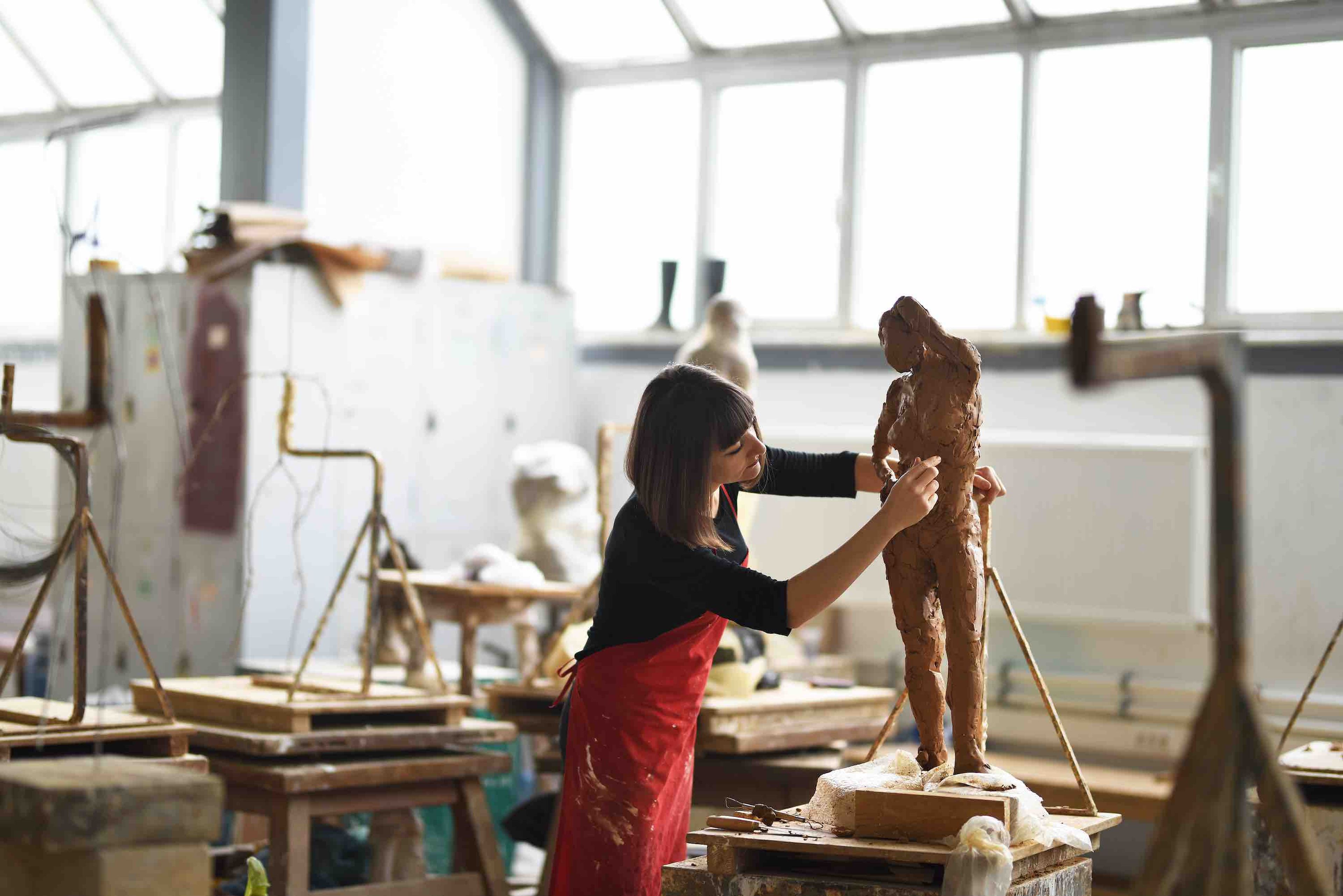 Una mujer disfruta mientras hace una escultura.