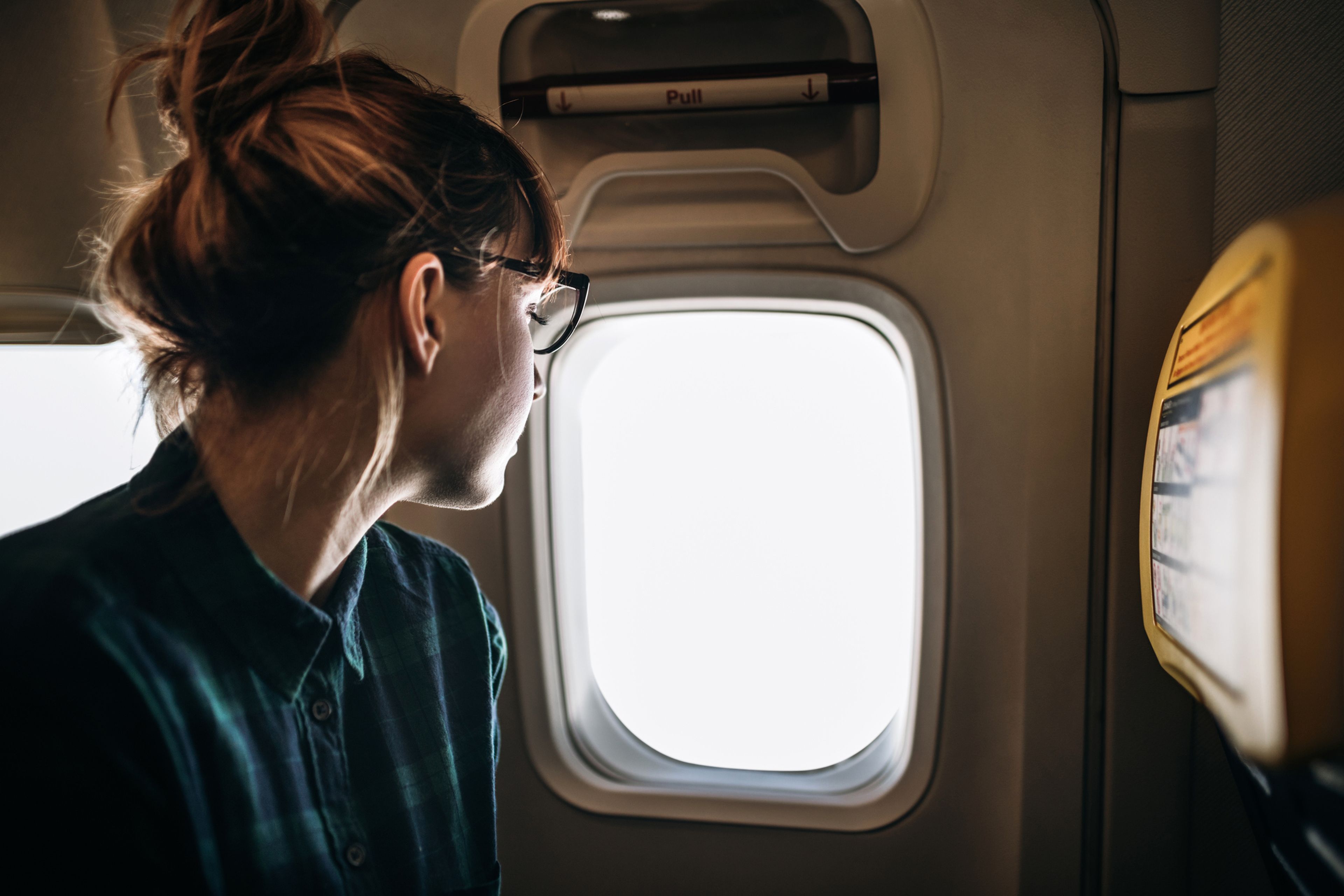 Mujer mirando por la ventanilla de un avión.