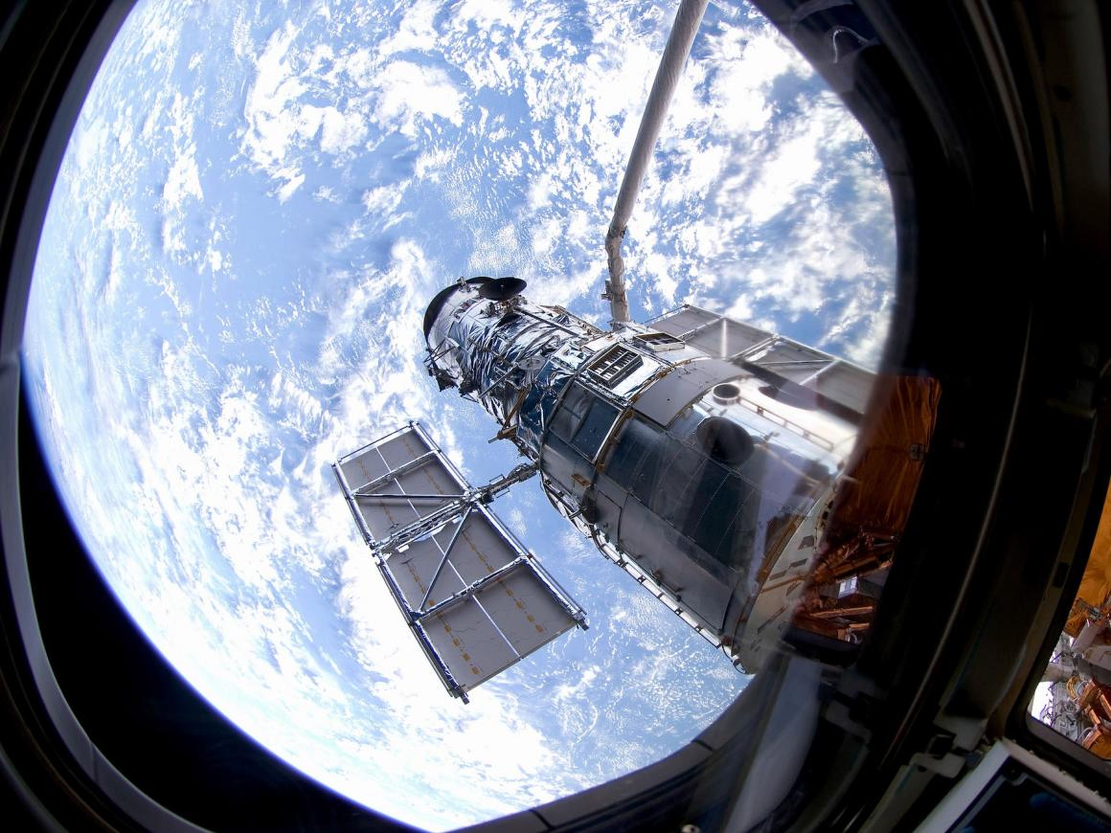 El telescopio Hubble orbitando alrededor de la Tierra.